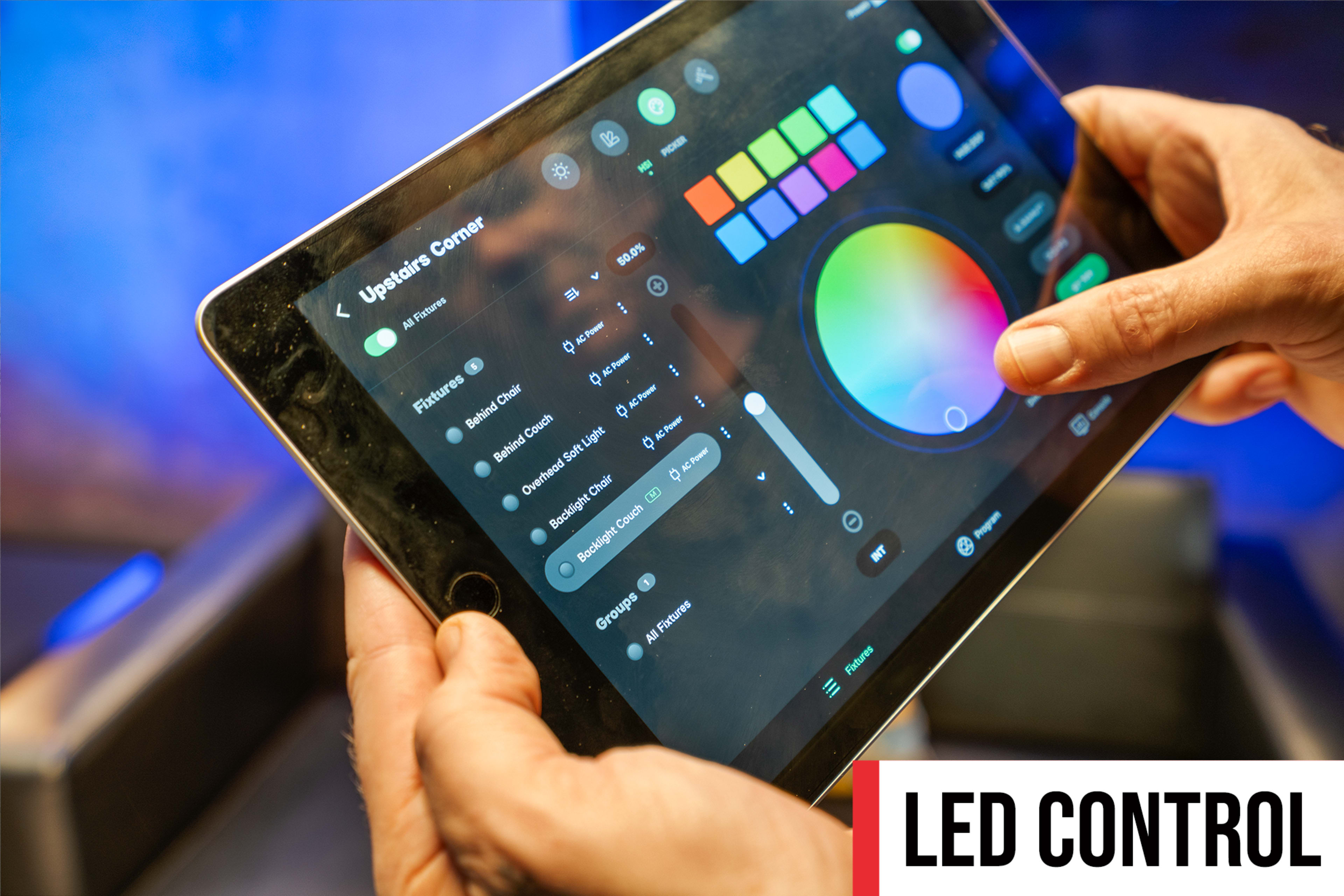 A person is using a tablet to control LED lighting settings through a digital interface.