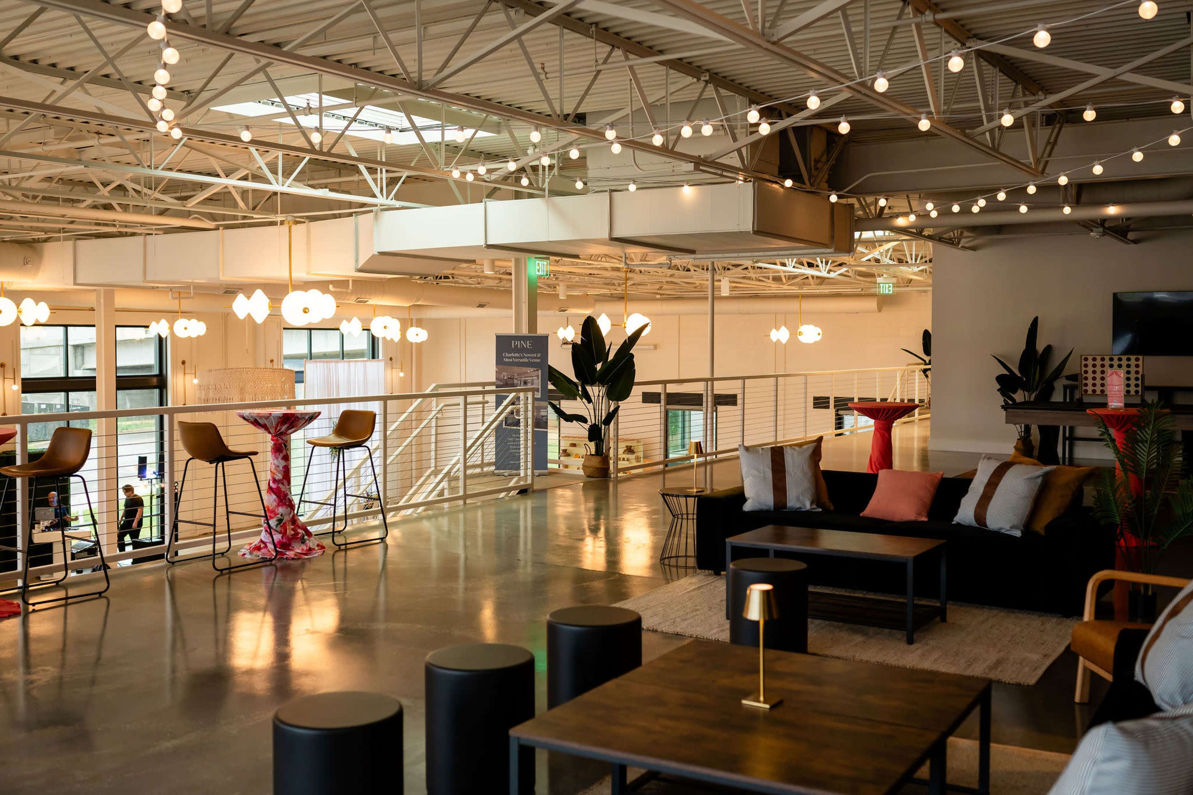 The image shows a modern, open space with seating areas, decorative plants, and soft lighting, designed for relaxation and socializing.