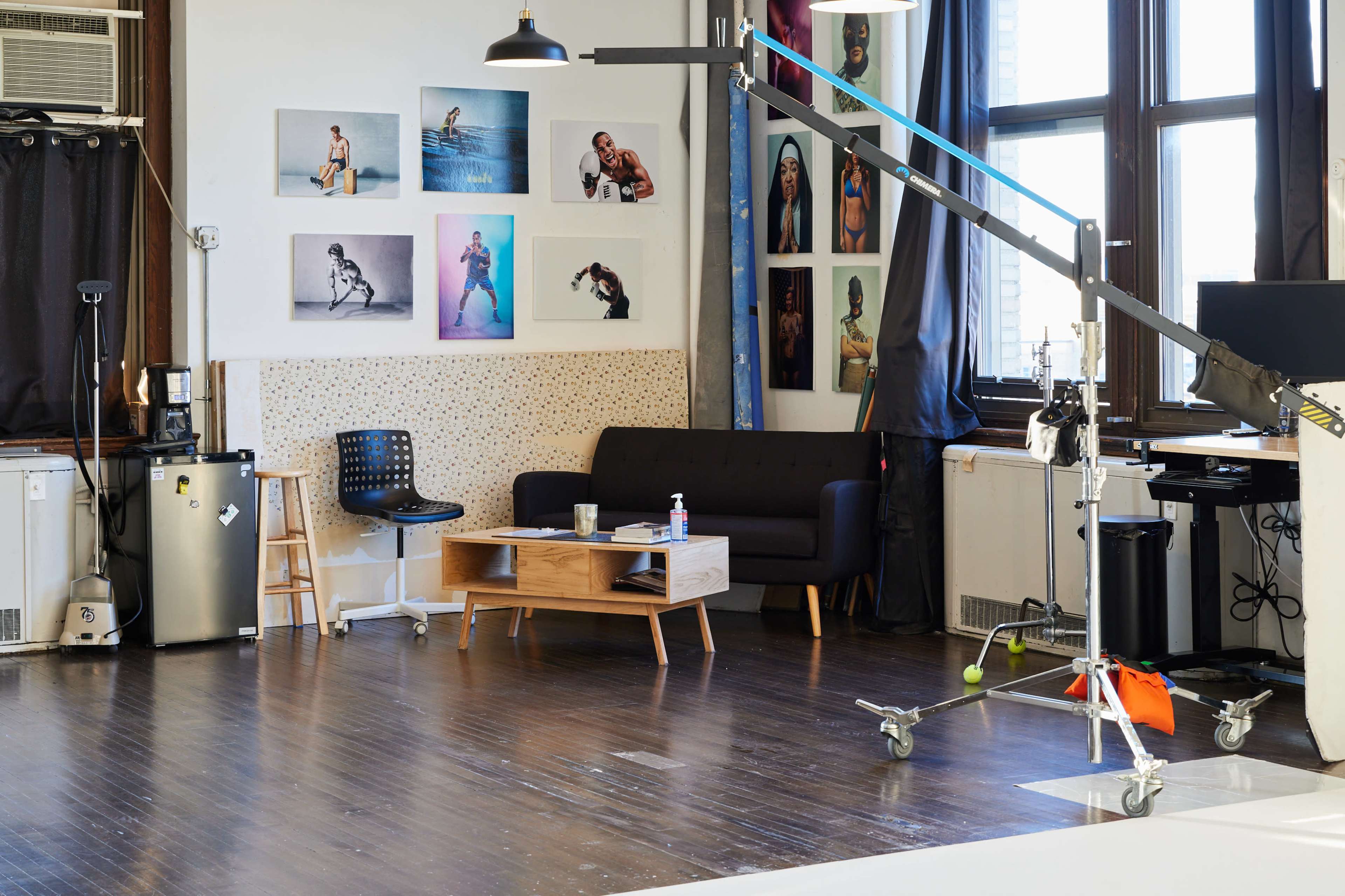 A photography studio with a couch, a coffee table, and framed photos on the walls.
