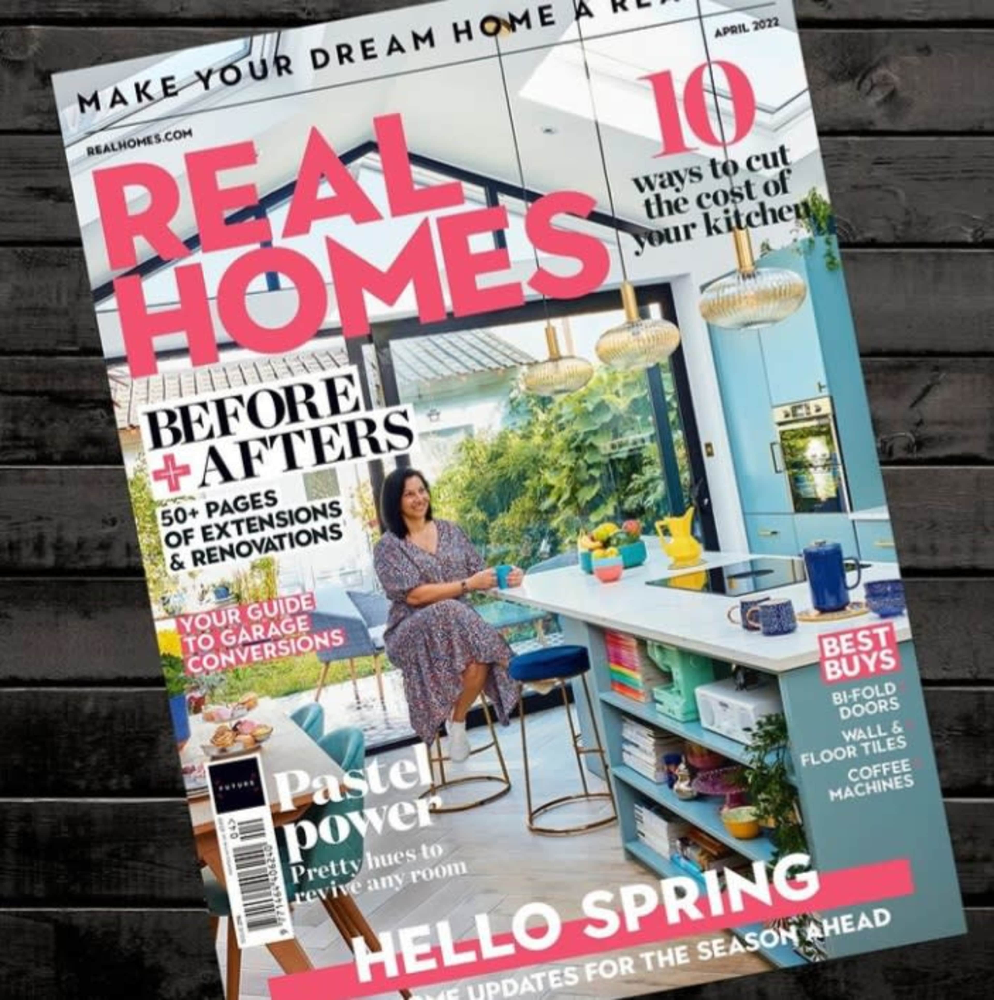The cover of a home and lifestyle magazine titled "Real Homes" with an article on kitchen costs and a woman sitting at a kitchen island.