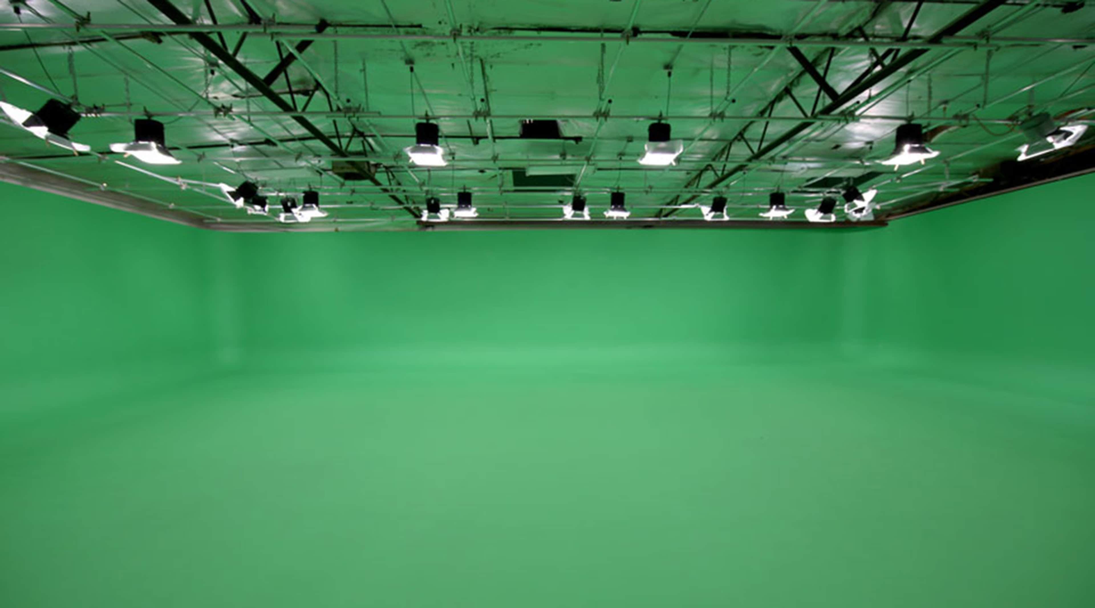 A green screen studio with evenly spaced lighting fixtures on the ceiling.
