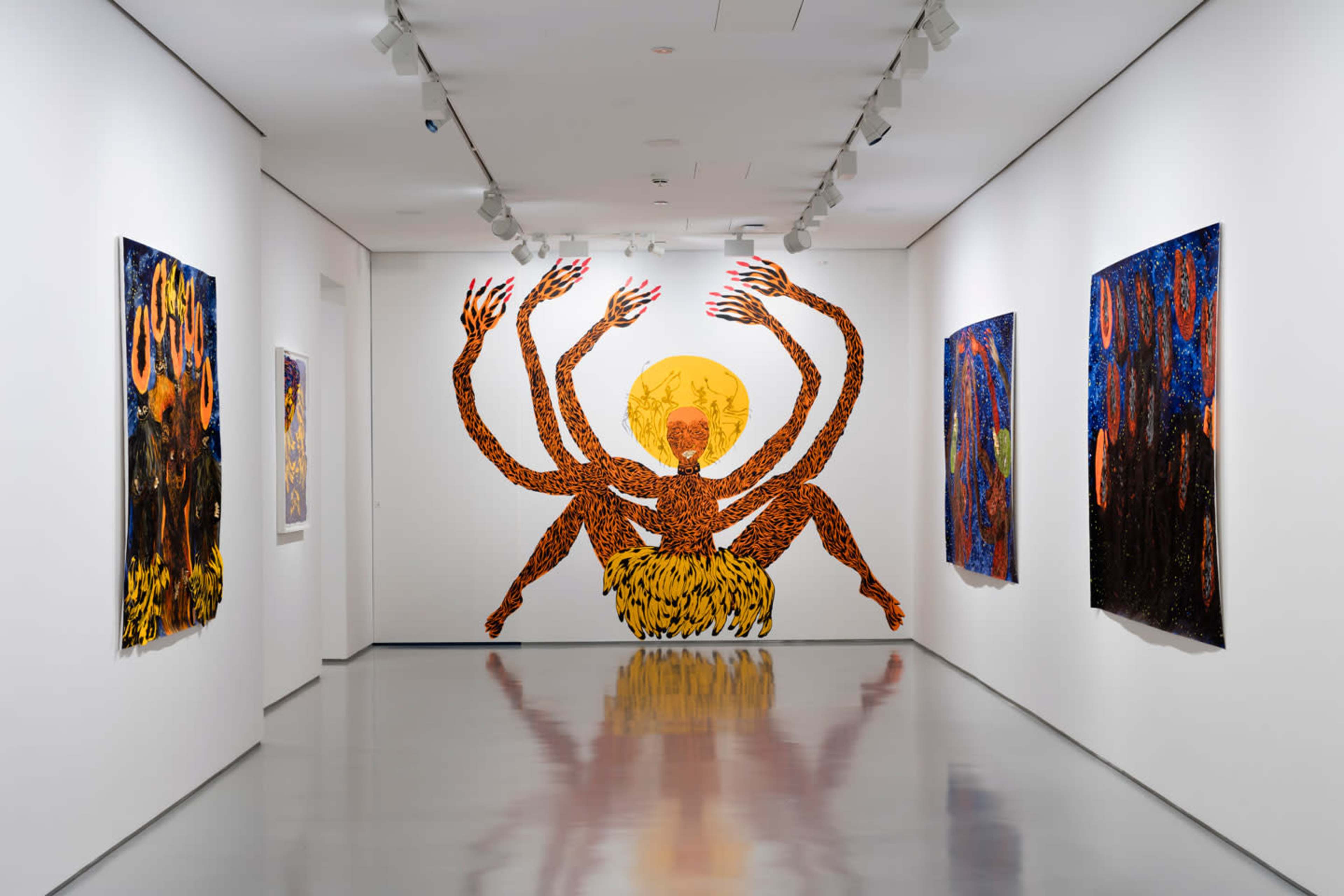 The image shows an art gallery with four colorful wall artworks, including a prominent mural of a figure with multiple arms and a large sun at its center.