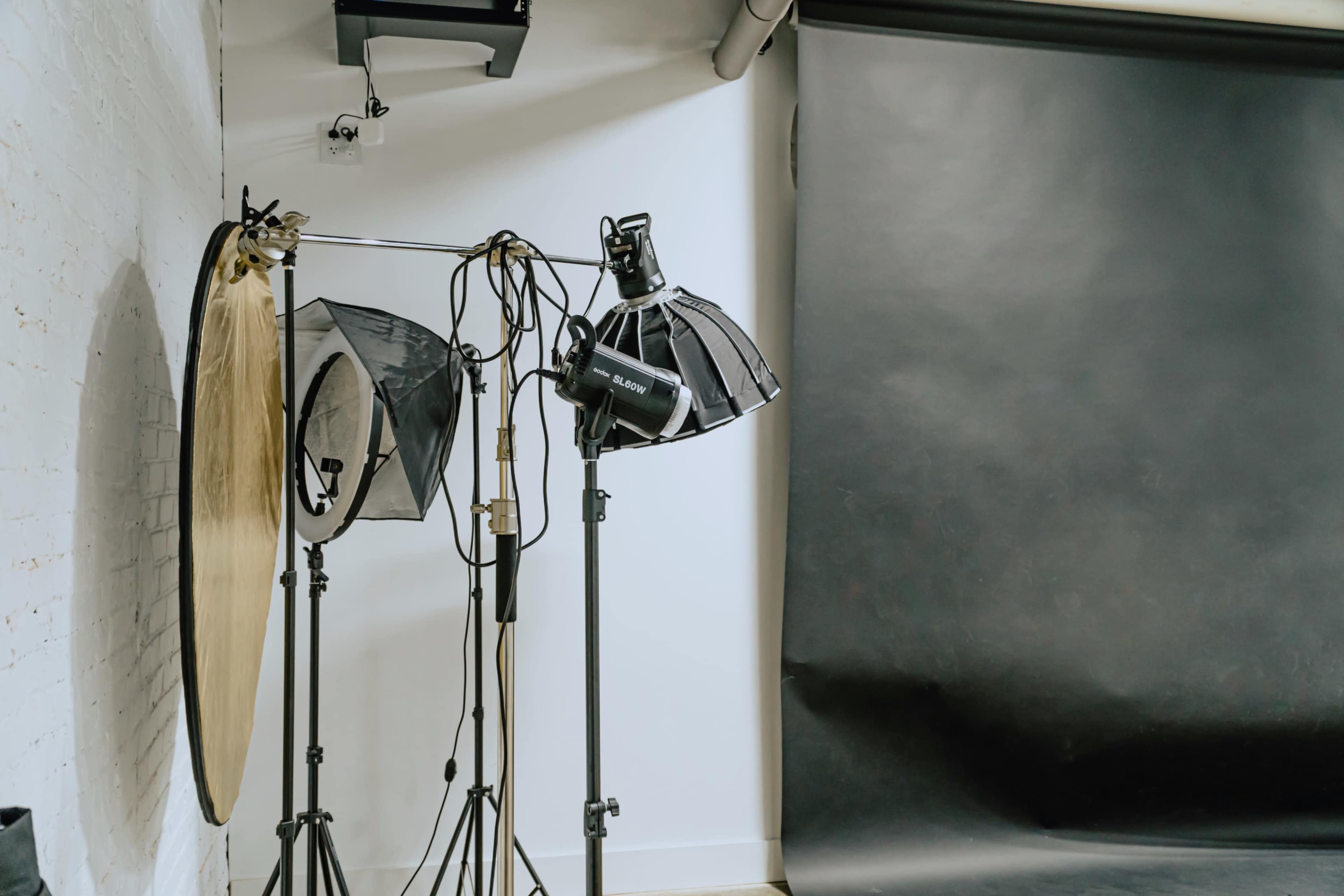 A photography studio setup features softbox lights and a black backdrop.