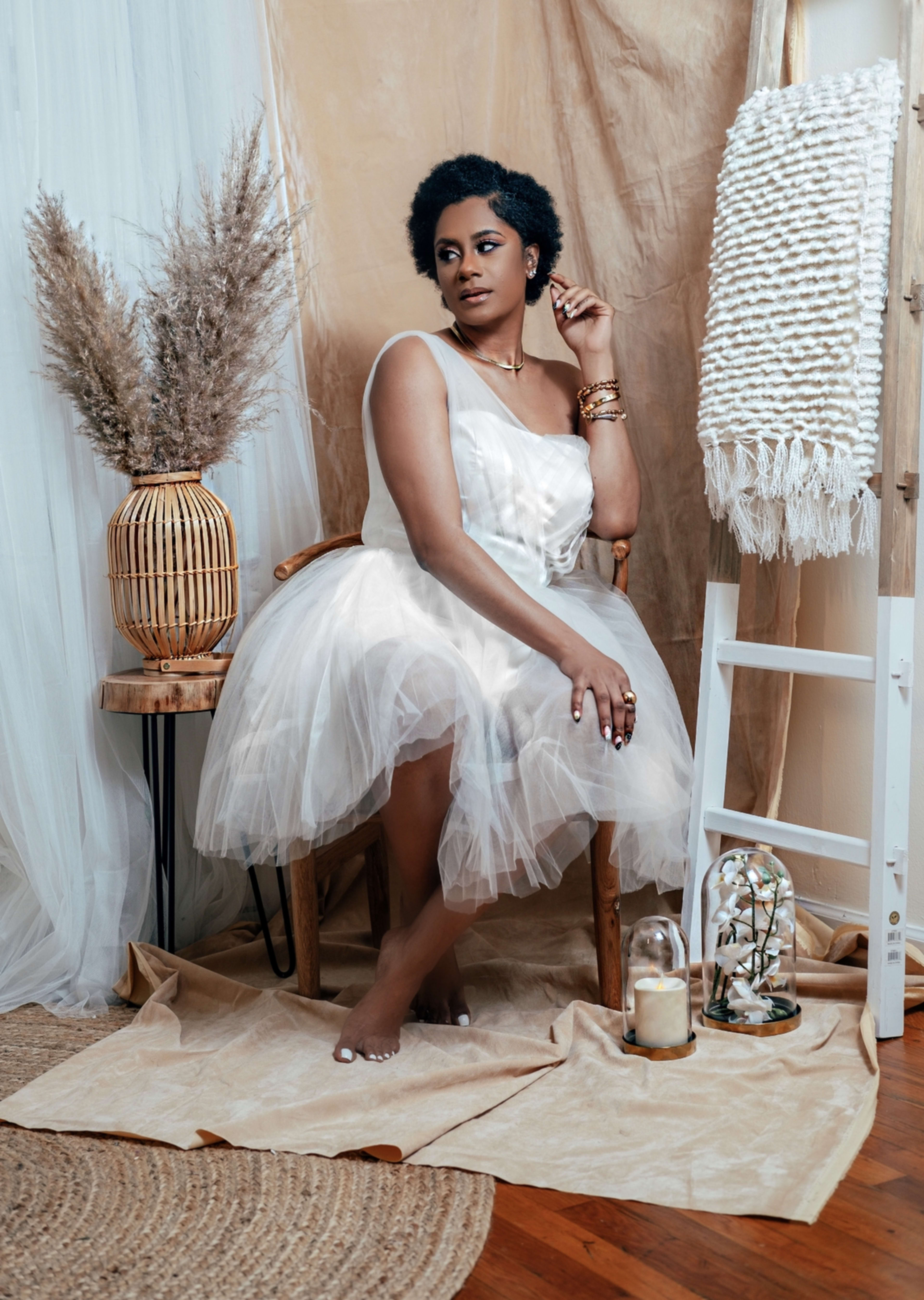 Una mujer con un vestido blanco posando para una sesión de fotos boho.