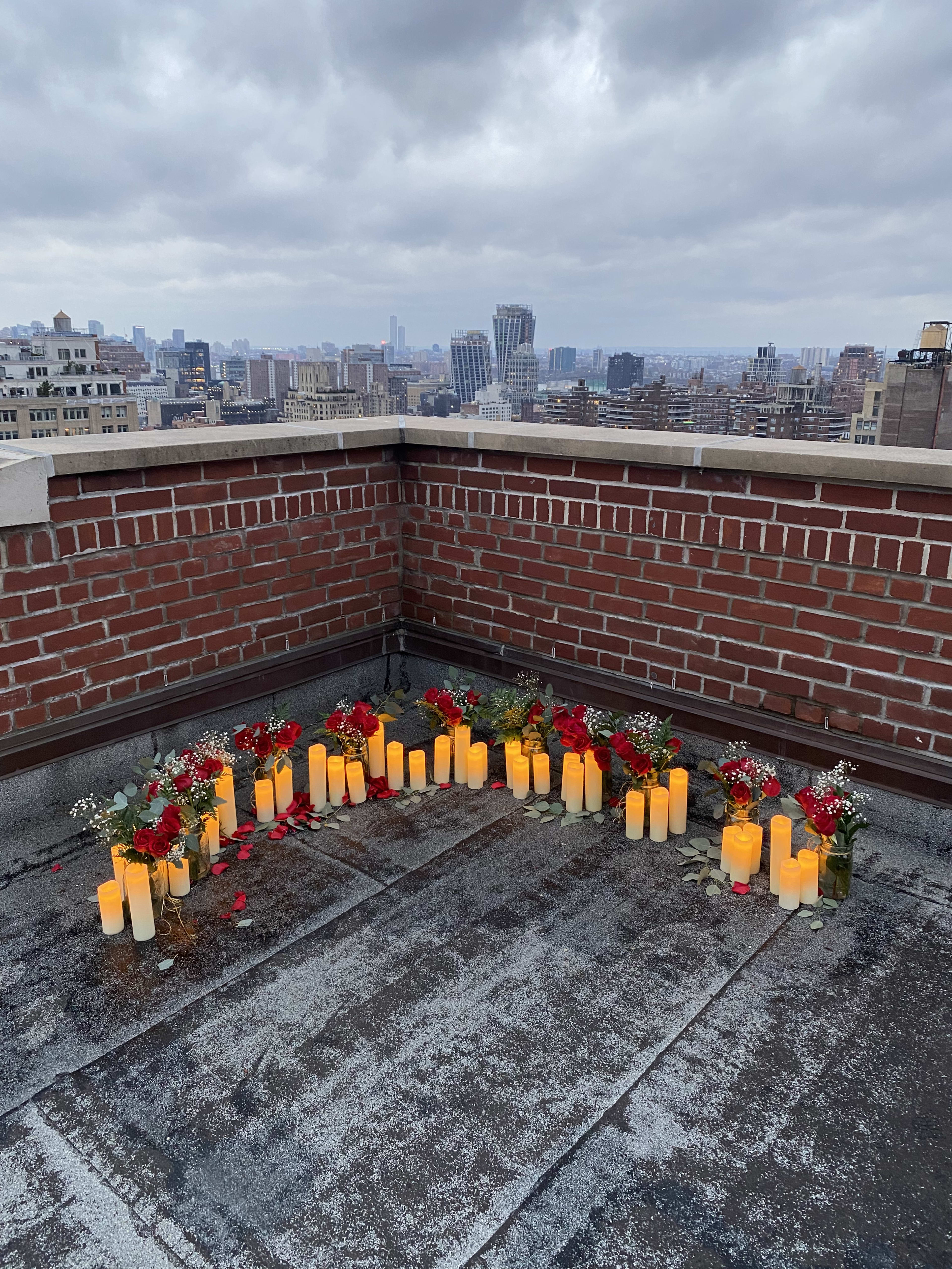 A row of outdoor candles in front of a brick wall for a party.