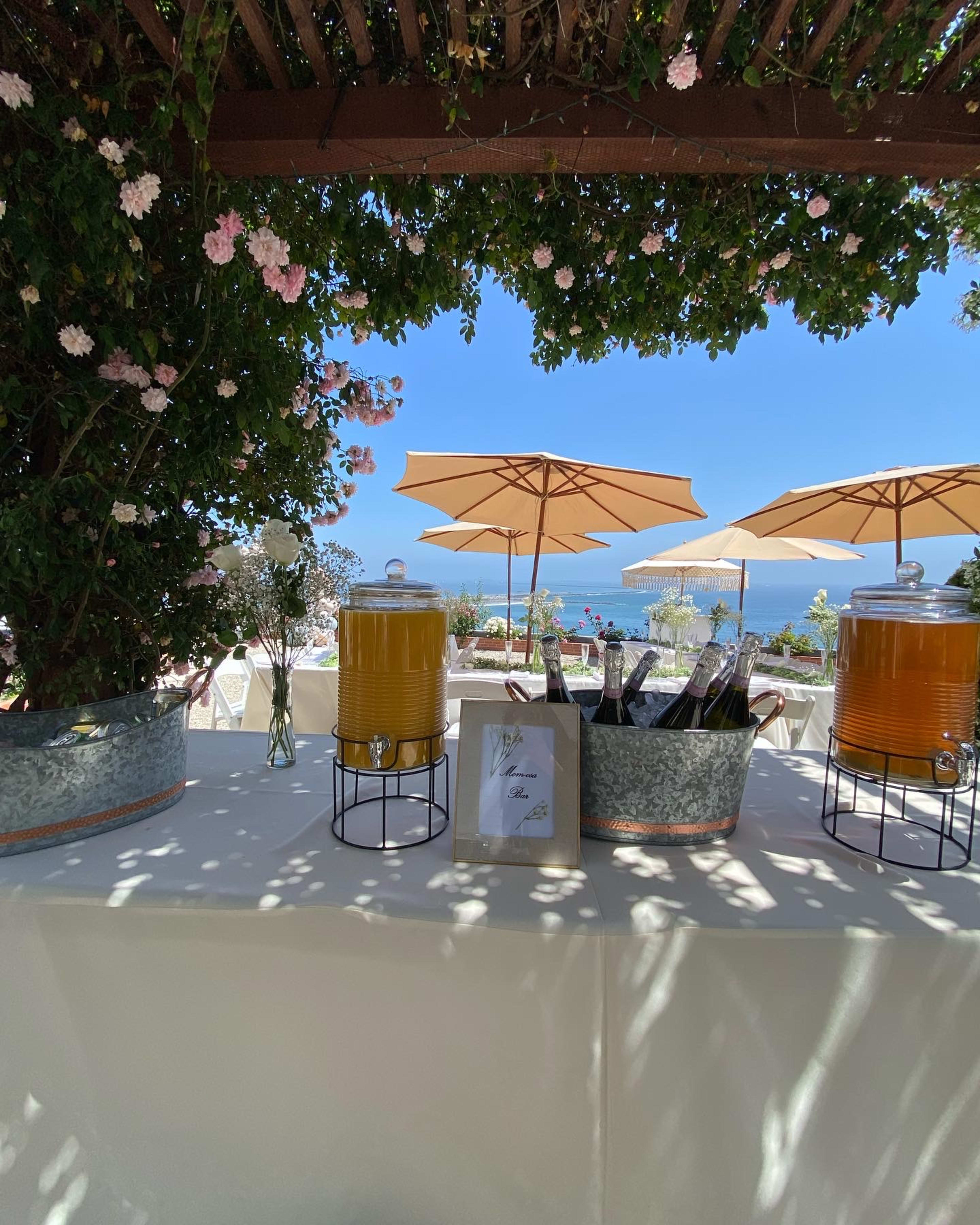 Une table en extérieure avec des boissons pour une fête estivale.