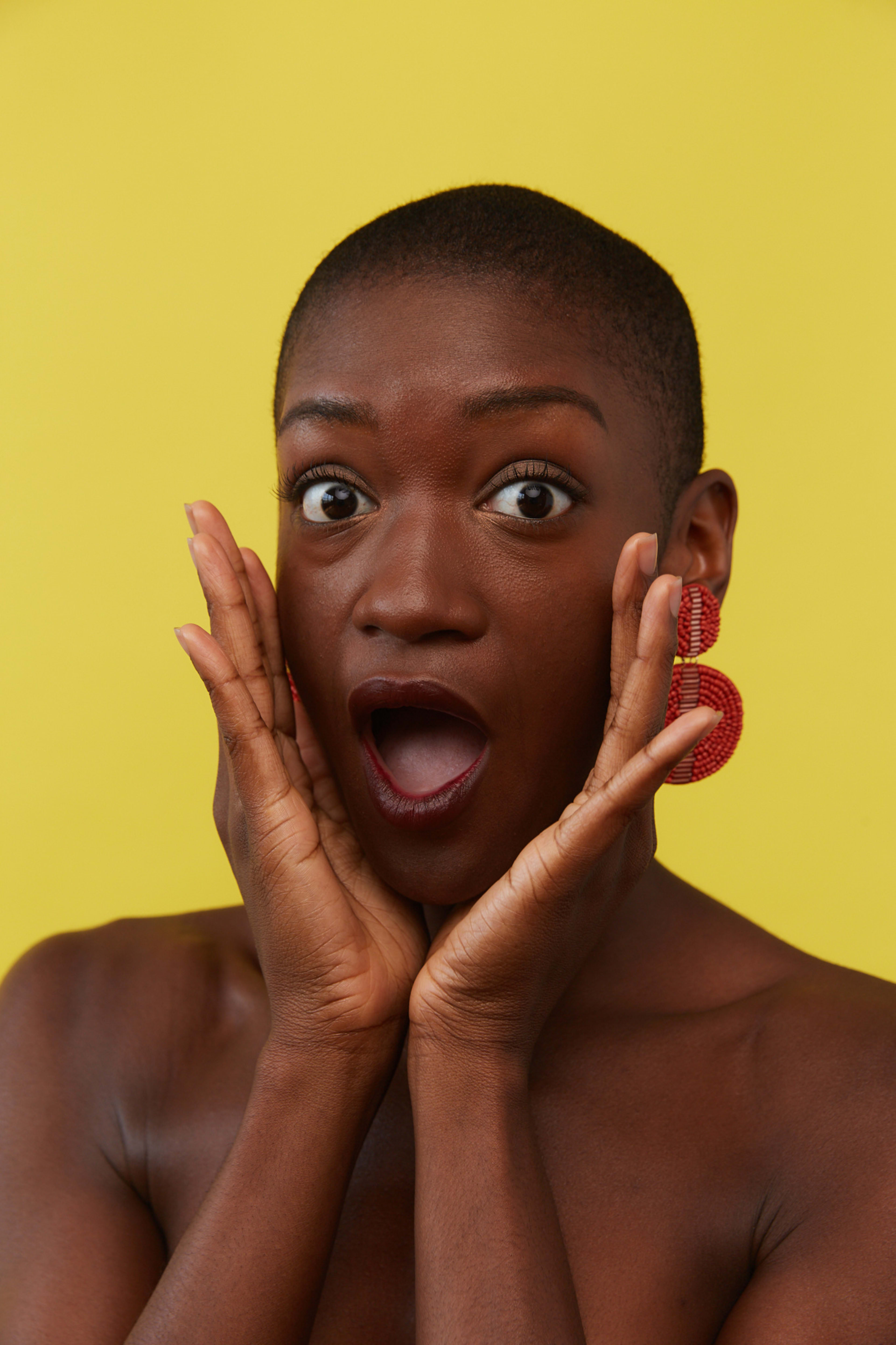 Eine Frau mit einem überraschten Gesichtsausdruck bei einem Fotoshooting.