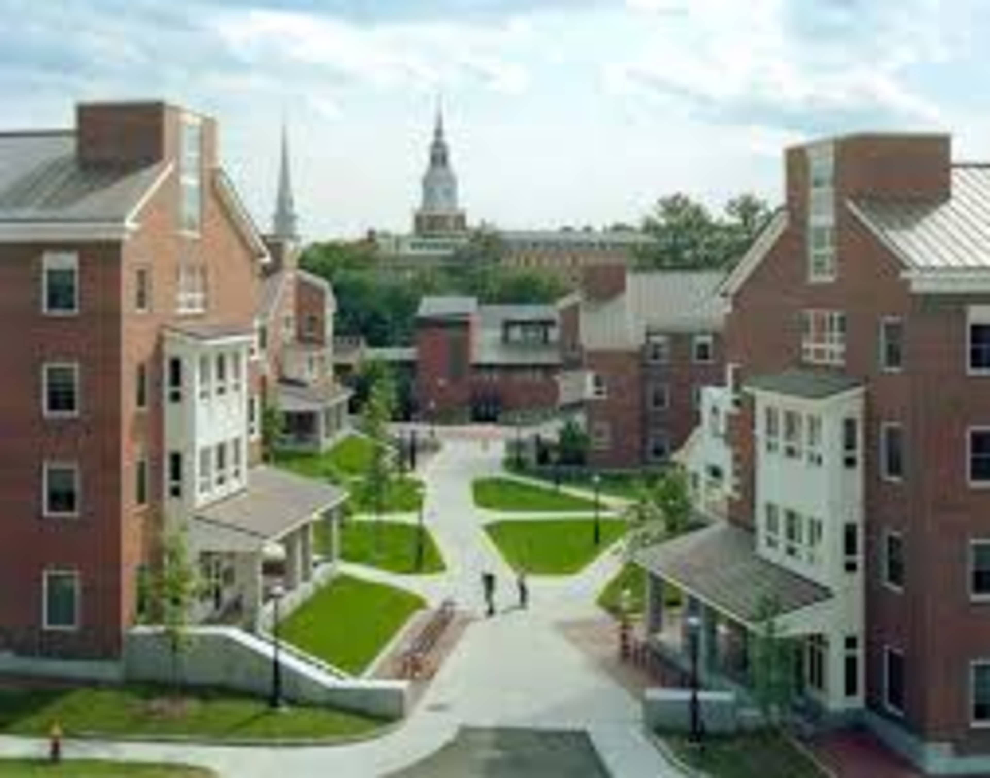 A view of a college campus featuring multiple brick buildings and landscaped pathways.