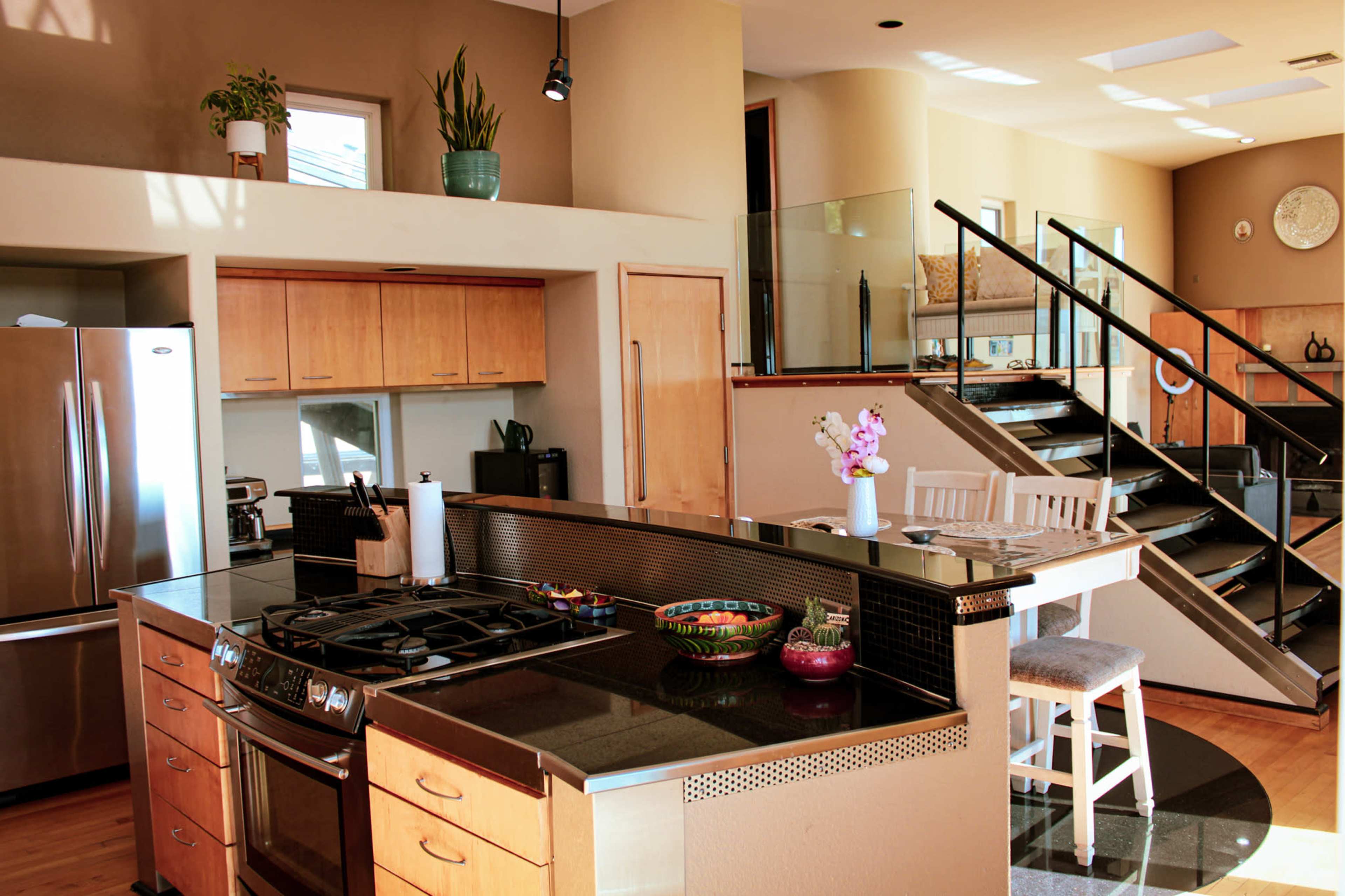 A modern kitchen featuring wooden cabinetry, a gas stove, and a breakfast bar with stools.