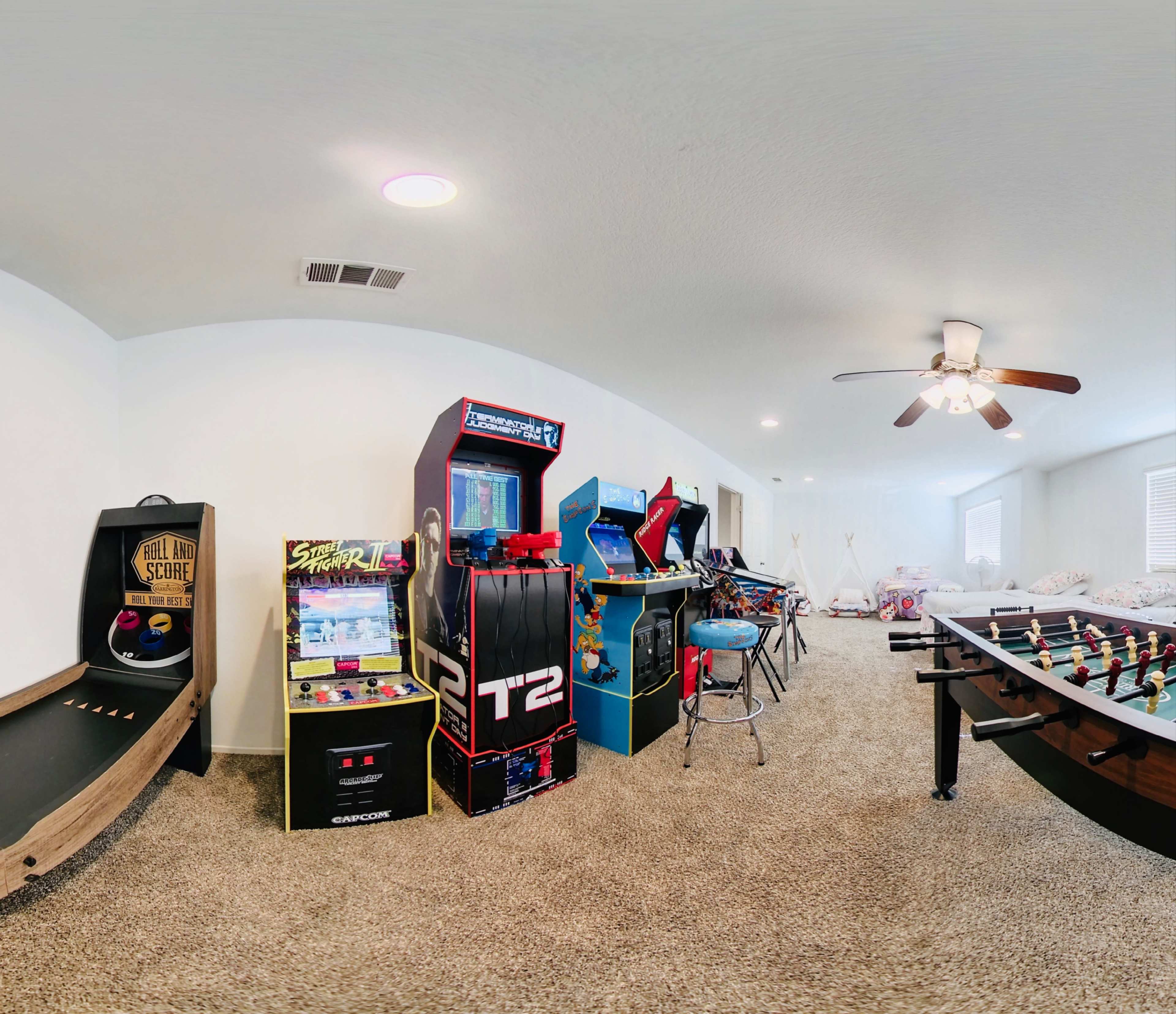 The scene features a game room with various arcade machines, a foosball table, and a carpeted floor.