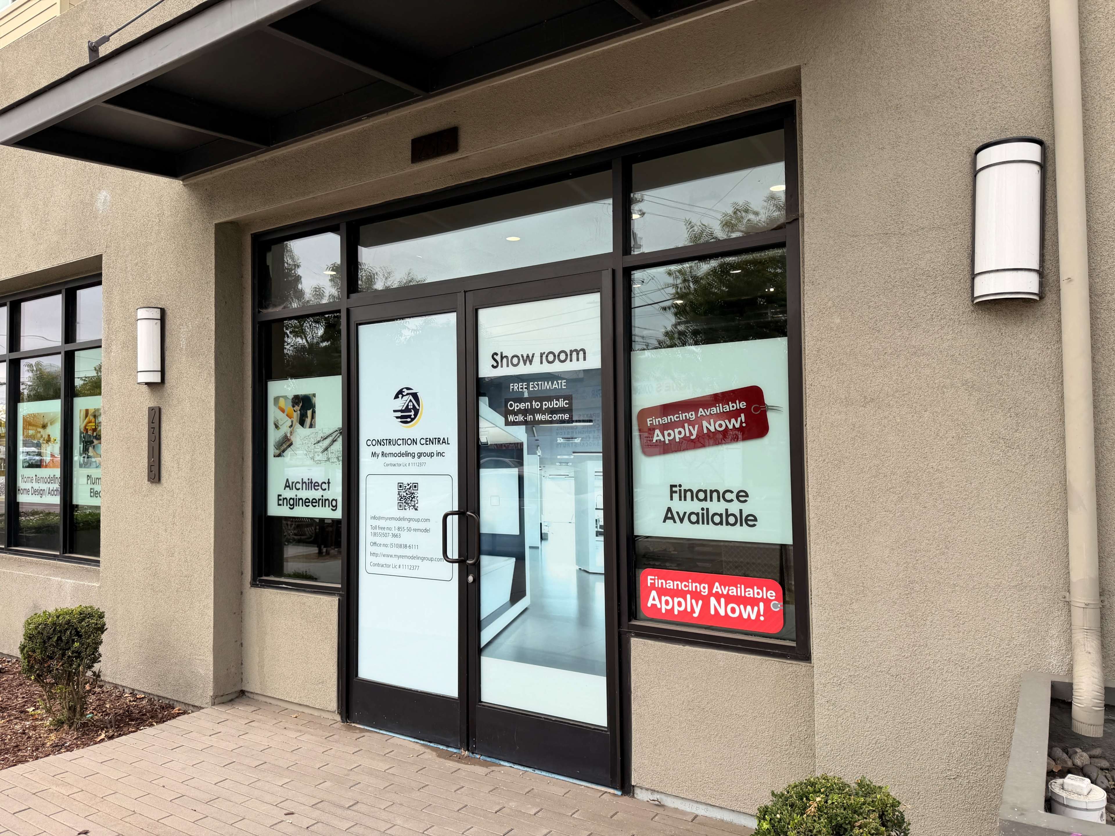 The image shows the entrance of a showroom with multiple signs indicating services, financing options, and an invitation for free estimates.