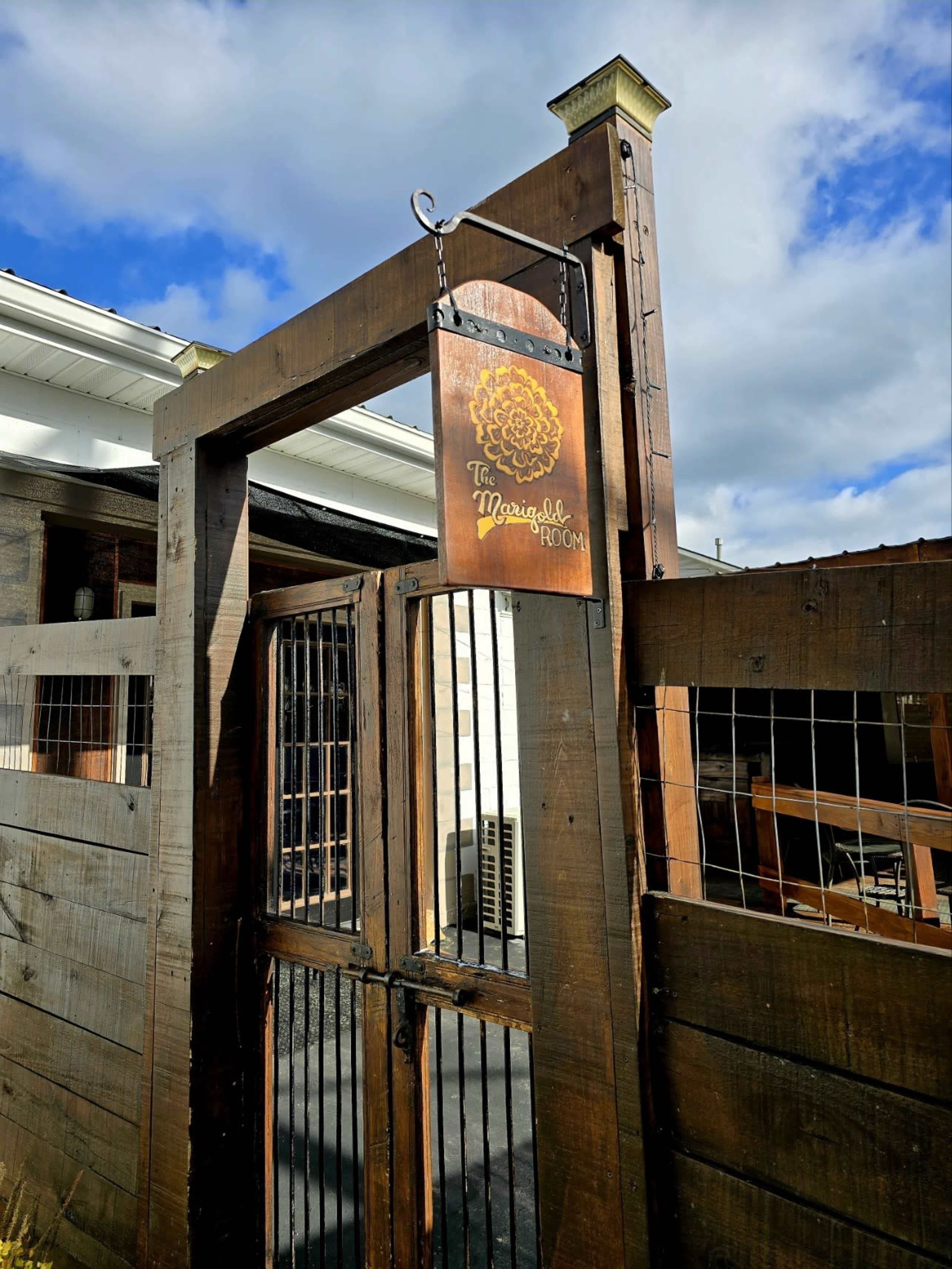 A wooden entrance gate displays a sign reading "The Merging Room."