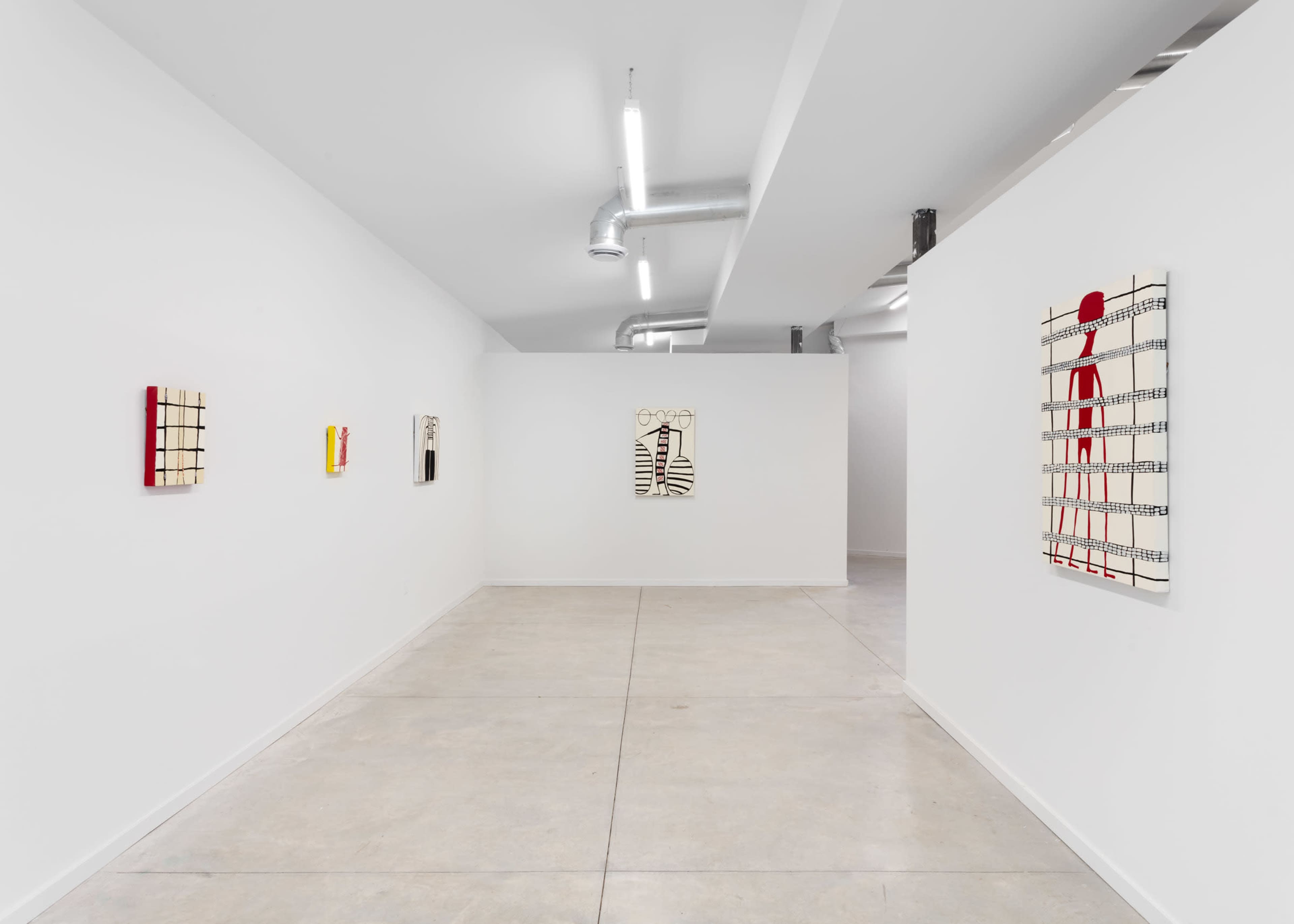 An interior art gallery with white walls featuring several abstract paintings displayed on the walls.