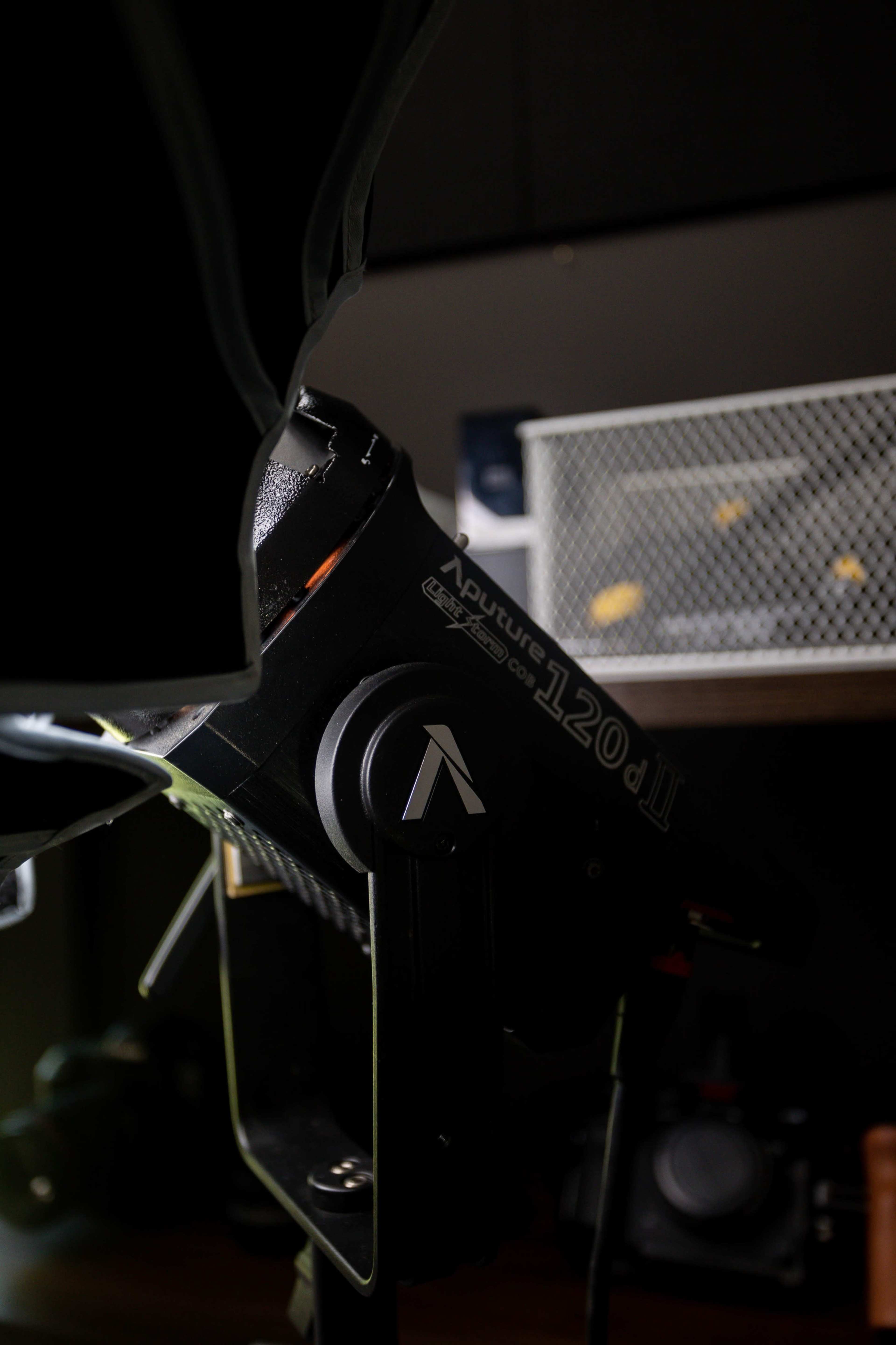 An Aputure 120D II light fixture positioned near a dark background.