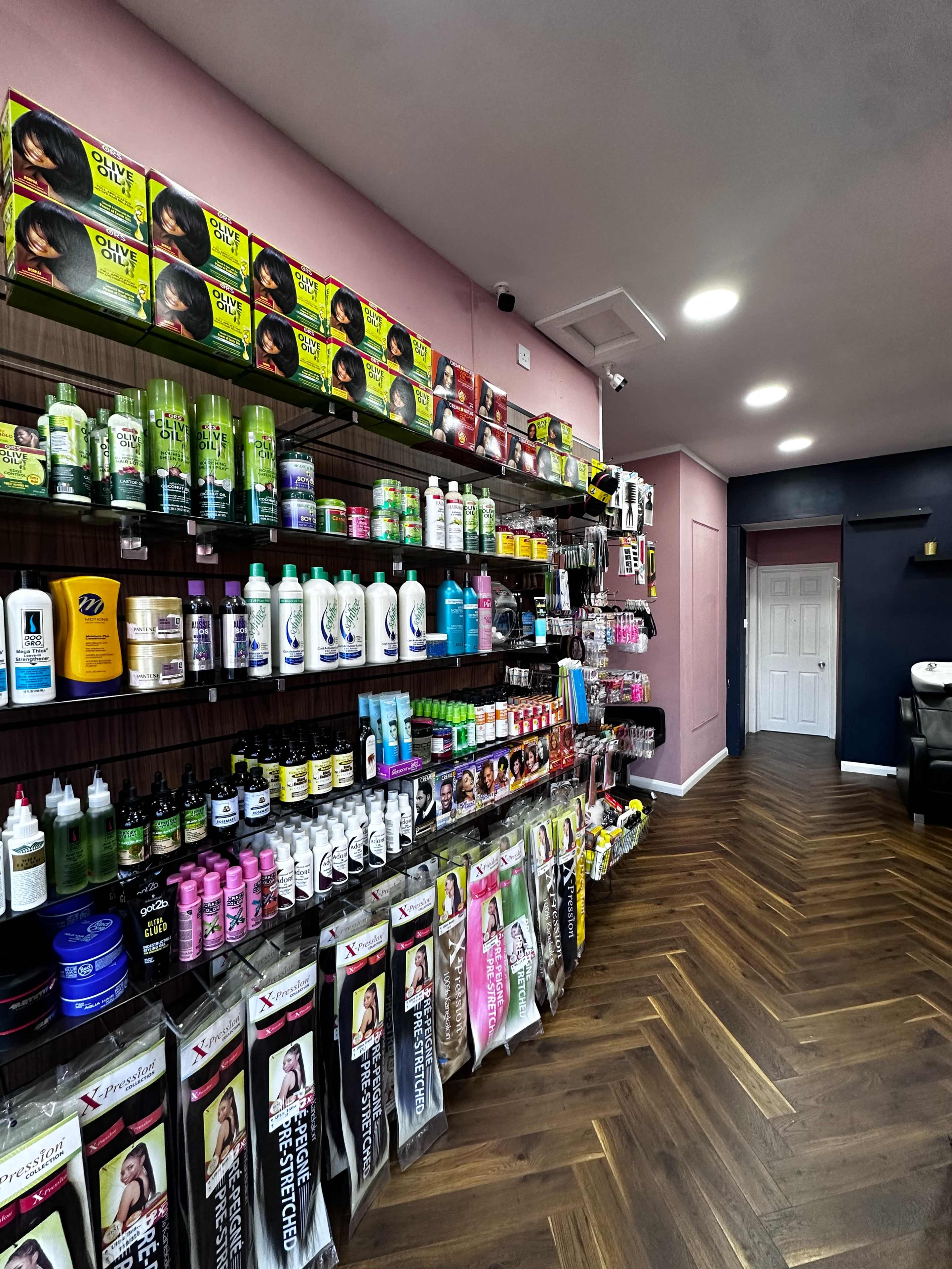 The image shows the interior of a beauty supply store with shelves displaying various hair care products, including shampoos, conditioners, and styling tools, along one wall.