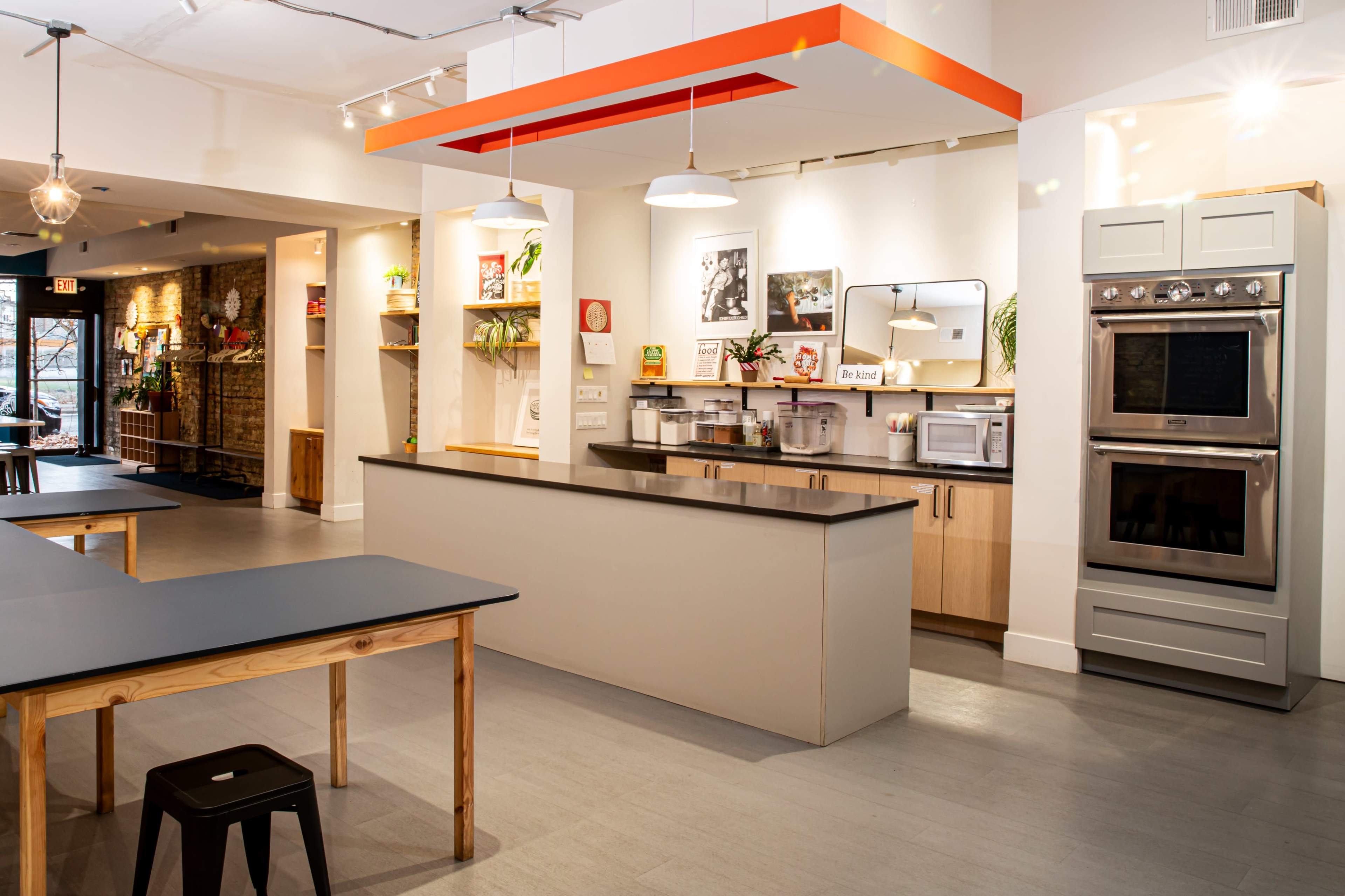 A modern kitchen with a central island, equipped with various appliances and decorative elements on the walls.