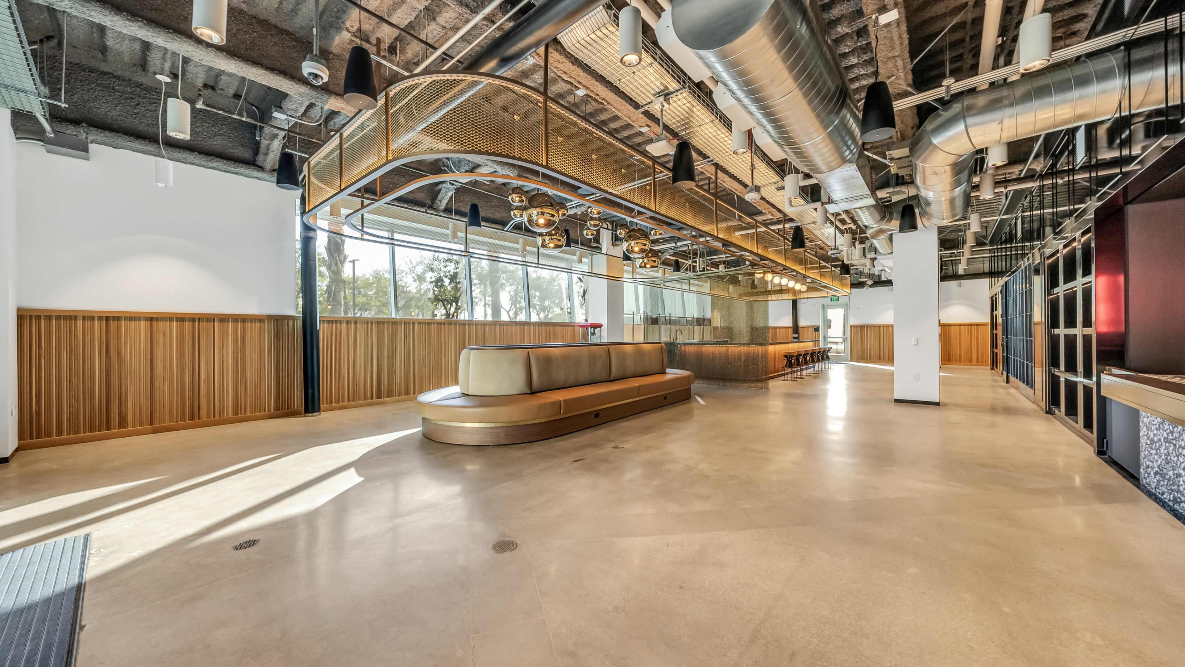 A spacious, modern office lobby with a curved seating area and extensive windows allowing natural light.