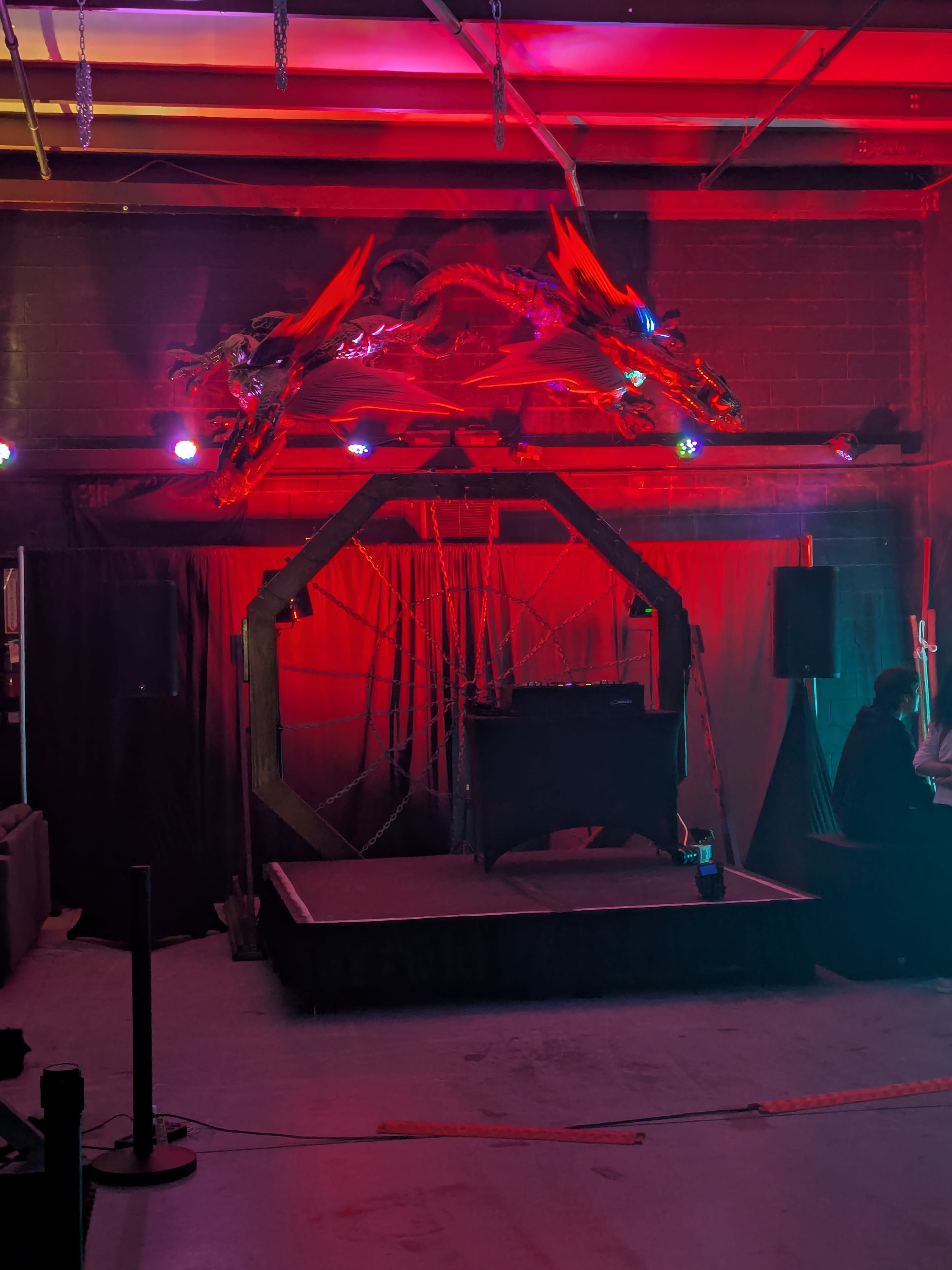 The scene features a dimly lit stage adorned with a decorative dragon motif and colored lighting, creating an atmosphere suitable for a performance or event.