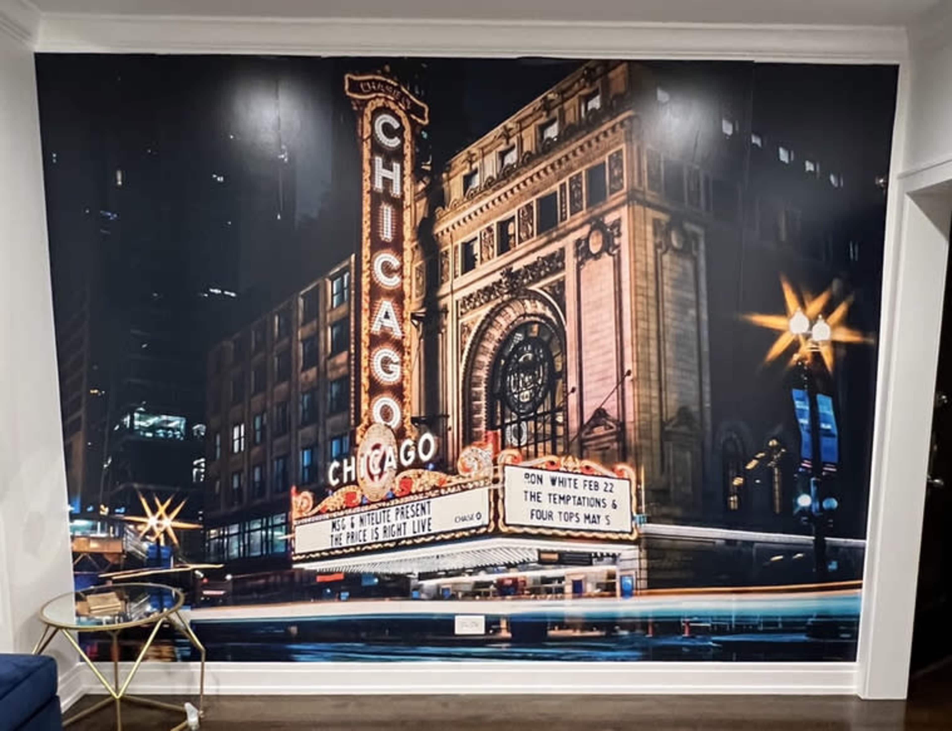 The image features a vibrant mural of the historic Chicago Theatre, showcasing its marquee and architectural details illuminated at night.