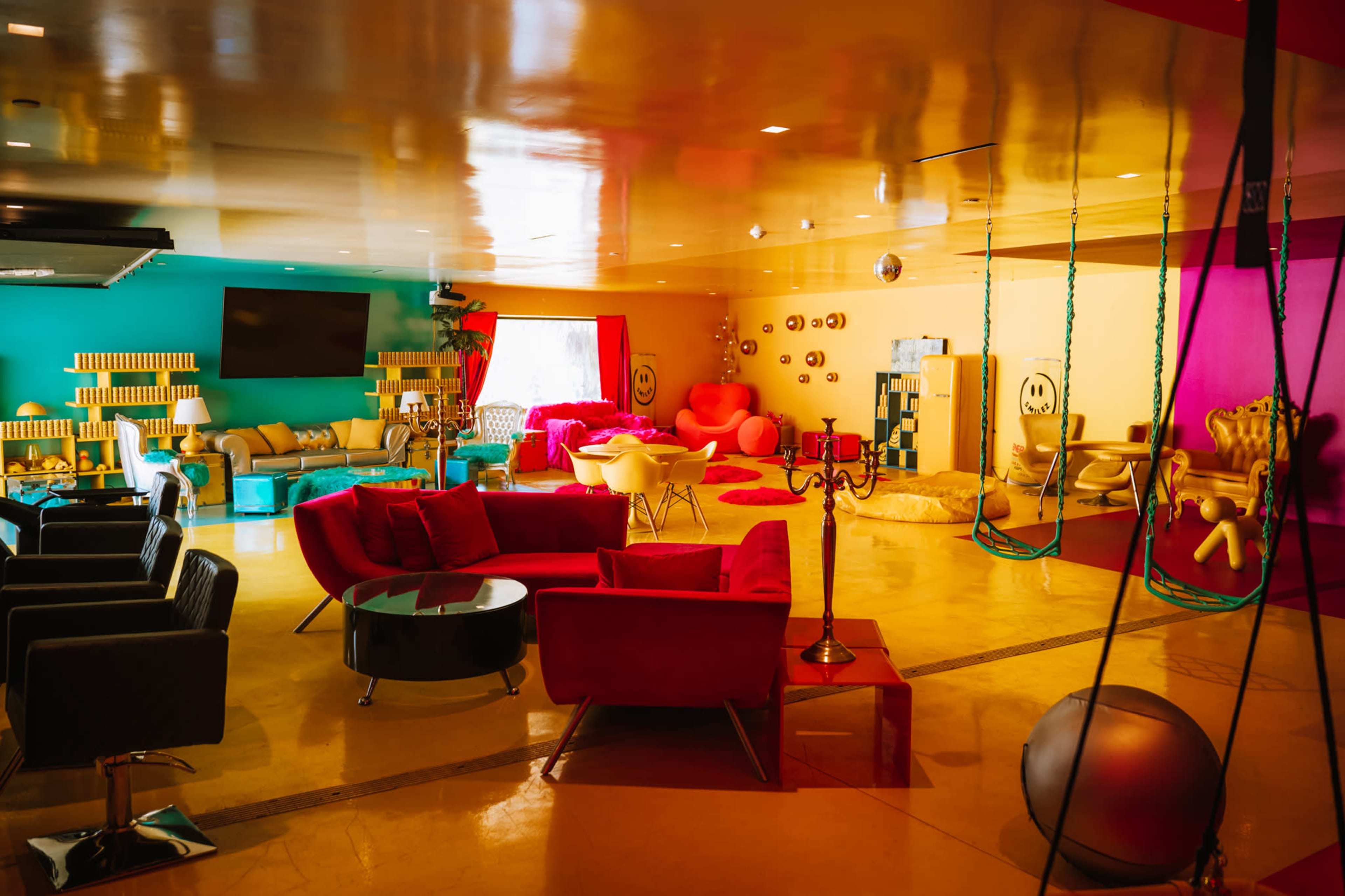 A brightly colored lounge area featuring various seating arrangements, vibrant walls, and playful décor elements.