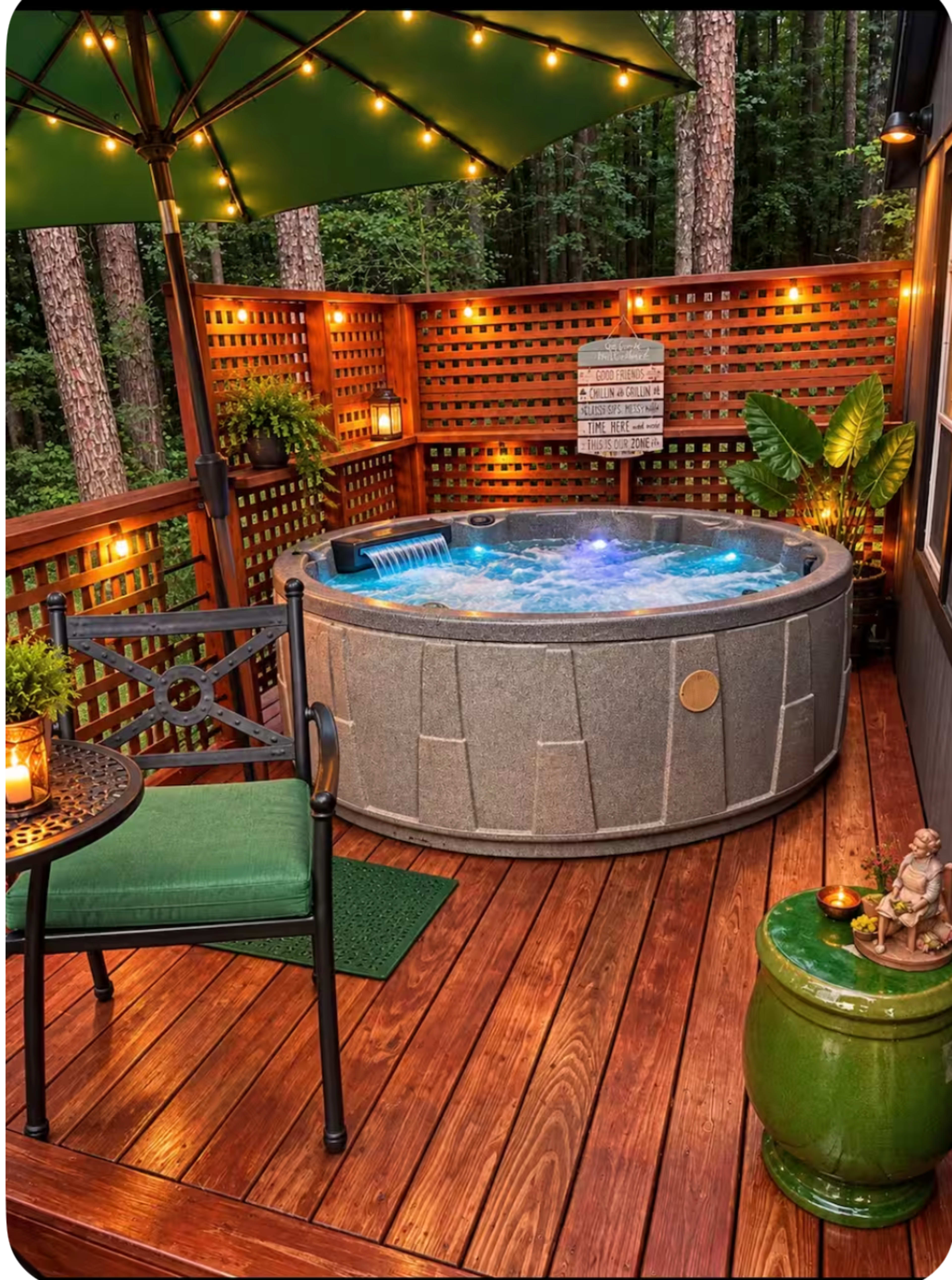 A hot tub with illuminated features is positioned on a wooden deck surrounded by a wooden lattice, a green chair, and decorative plants under soft lighting from an umbrella.