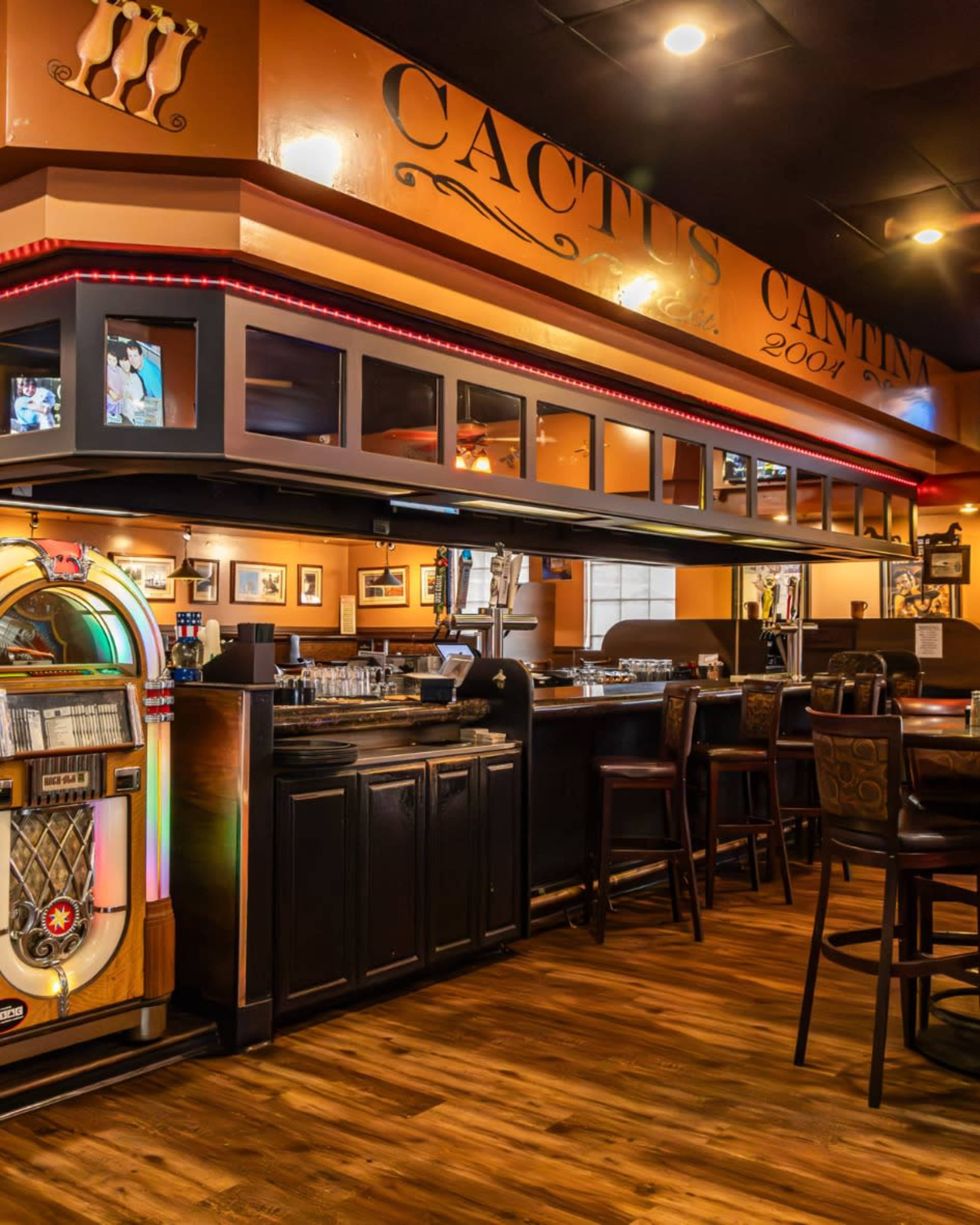 The image shows the interior of a restaurant bar, featuring a jukebox, dark wood furniture, and various decorations on the walls.