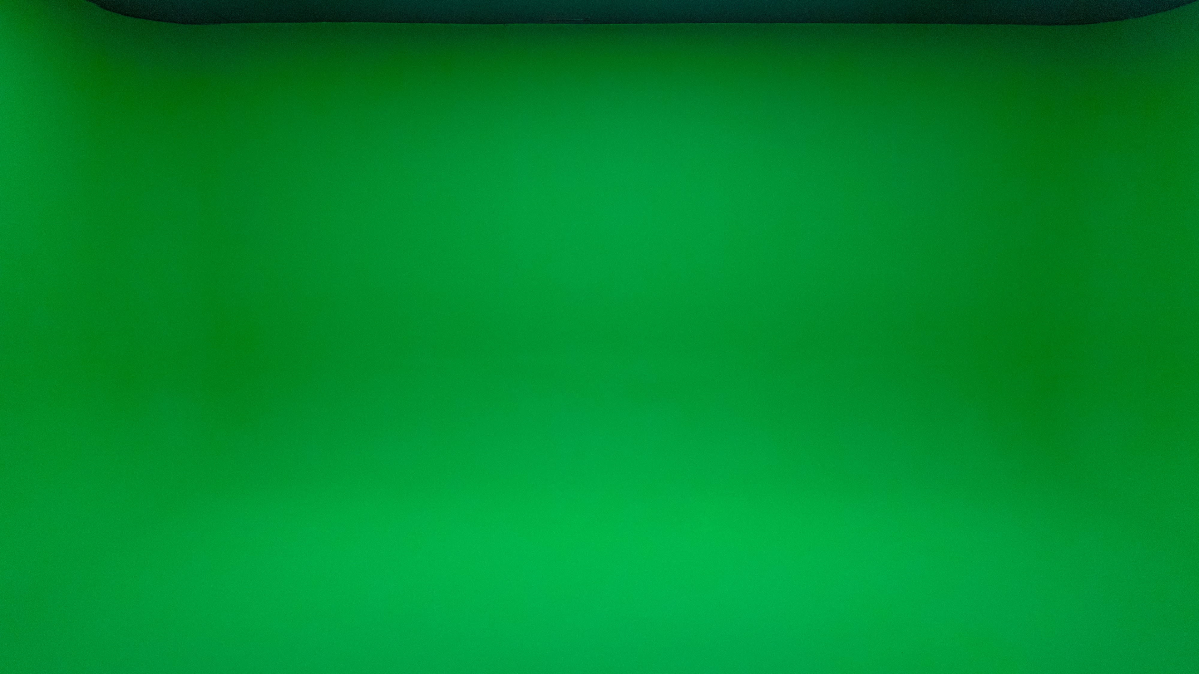 The image shows a plain green screen backdrop.