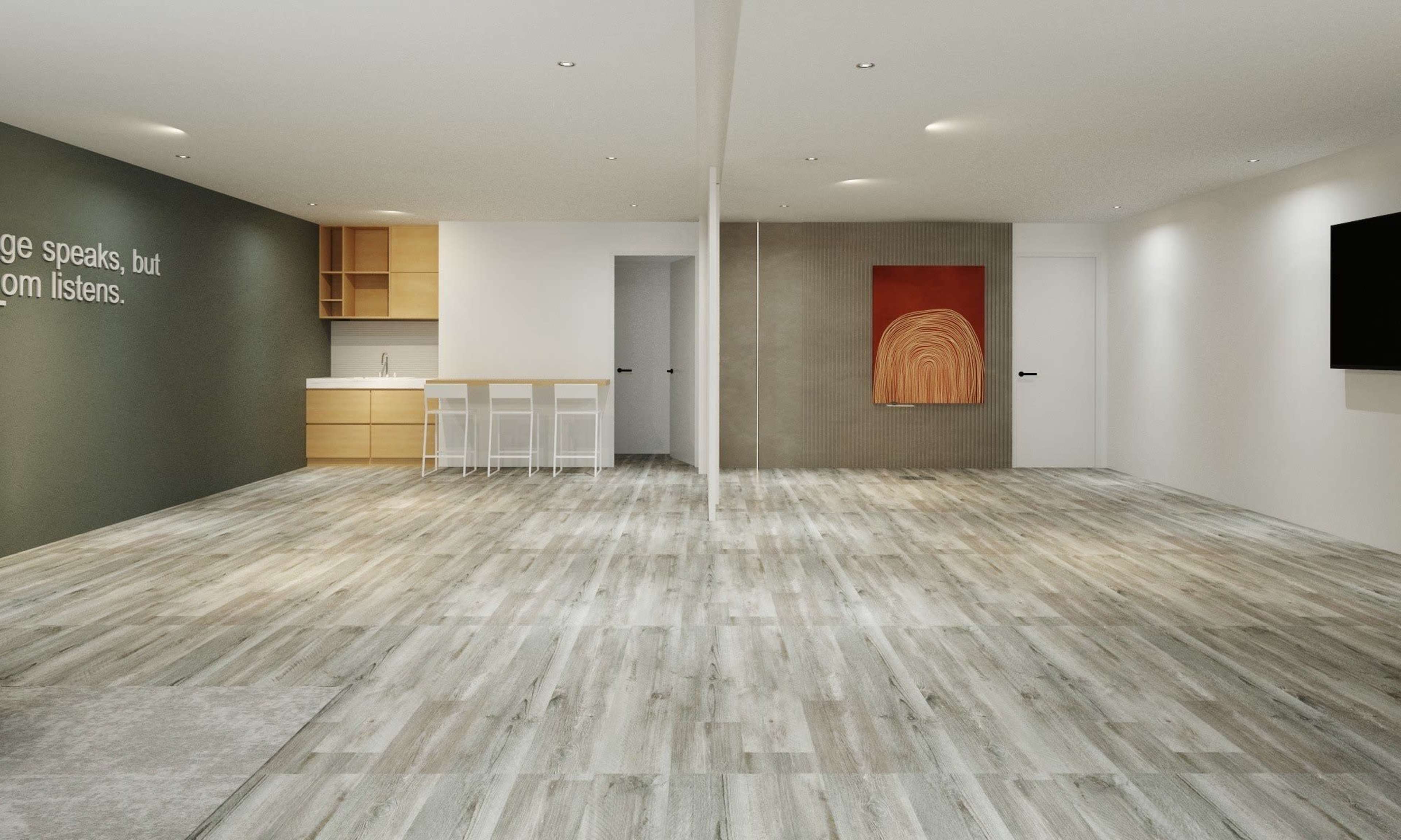 A spacious, modern room with wooden flooring and a minimalist kitchen area on one side, featuring a large wall with a piece of artwork.