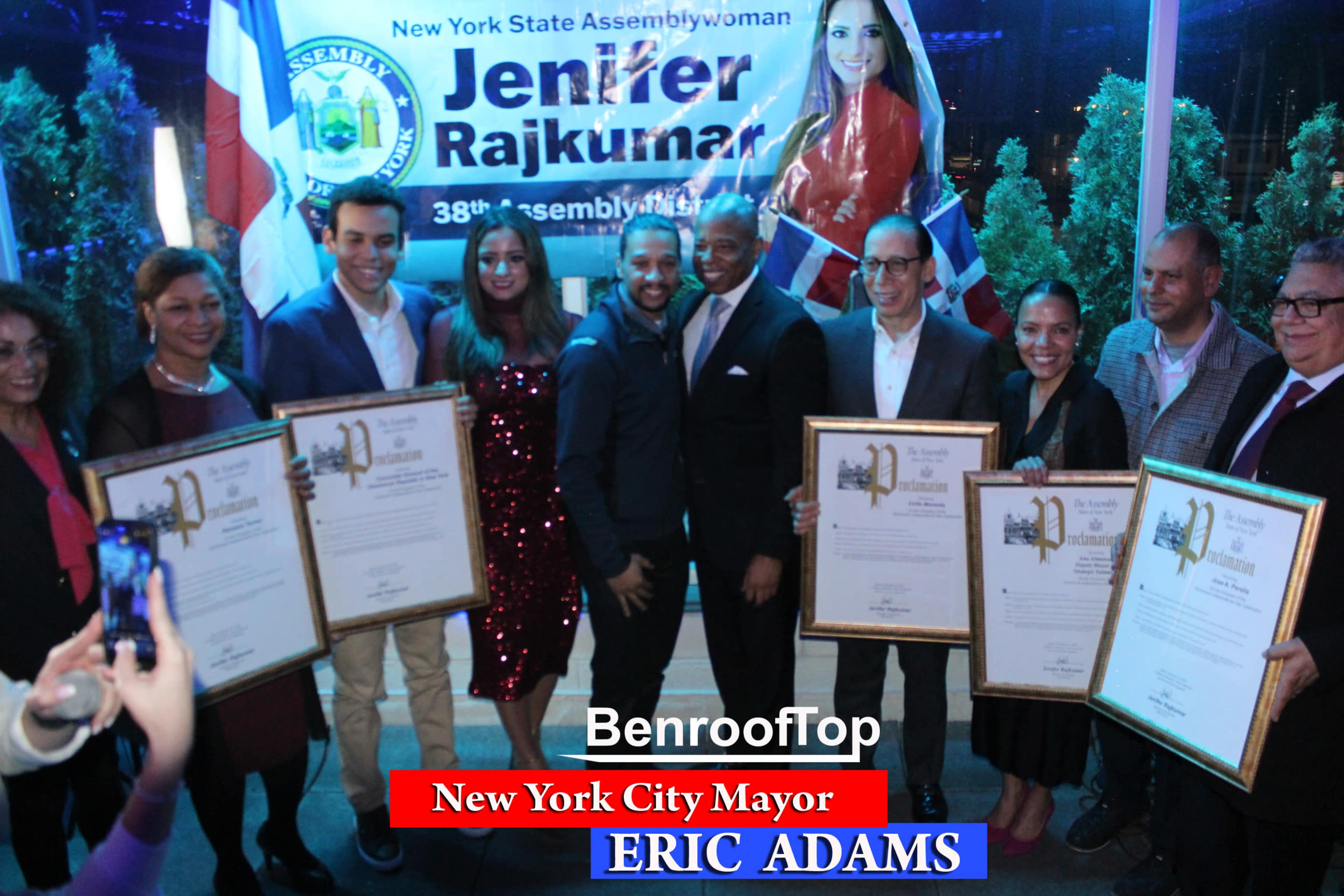 A group of people, including New York City Mayor Eric Adams, pose with certificates at an event honoring Assemblywoman Jennifer Rajkumar.