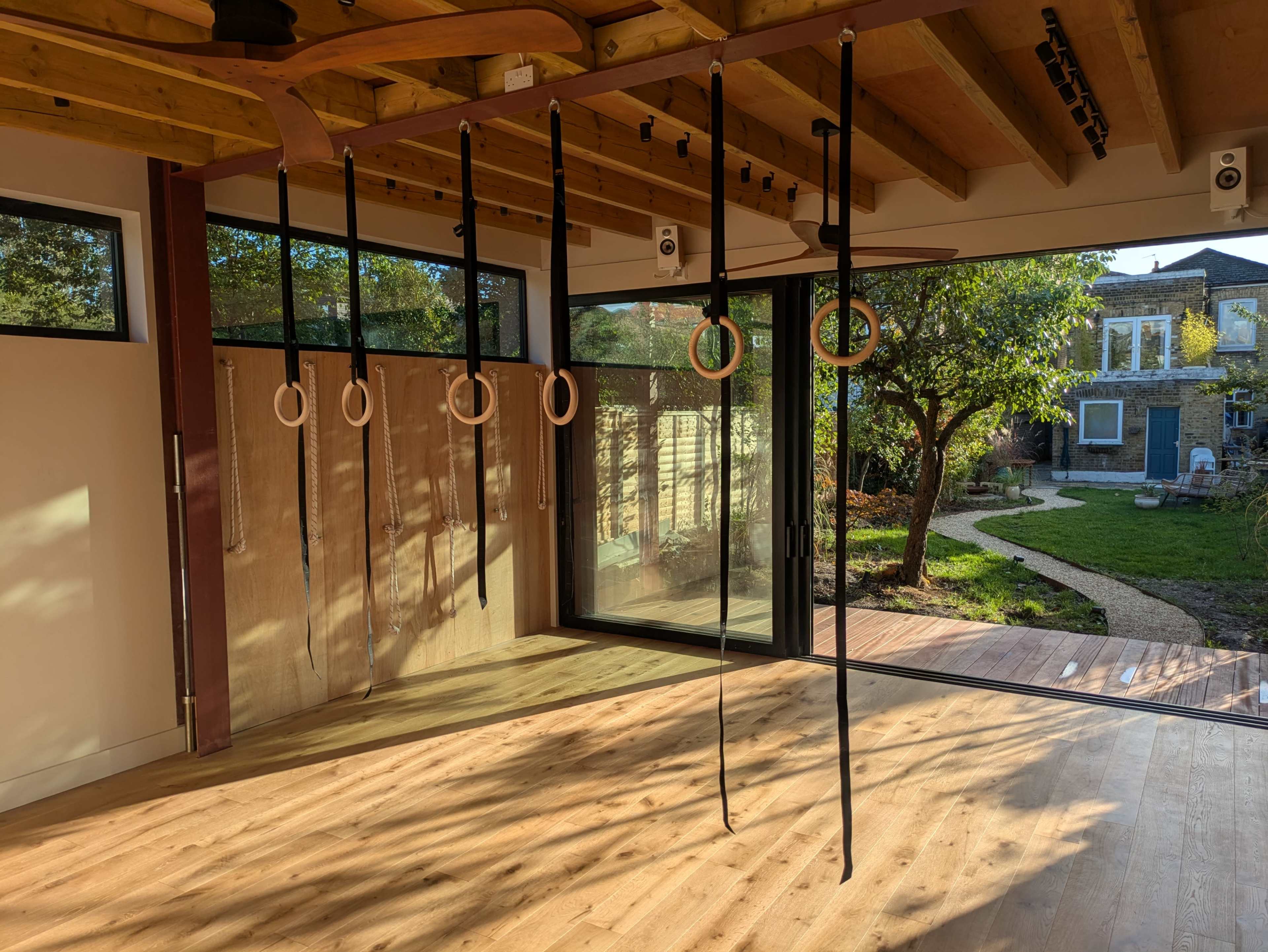 Light-filled movement studio in a garden, with natural wood accents Image in Leyton, London, ENG