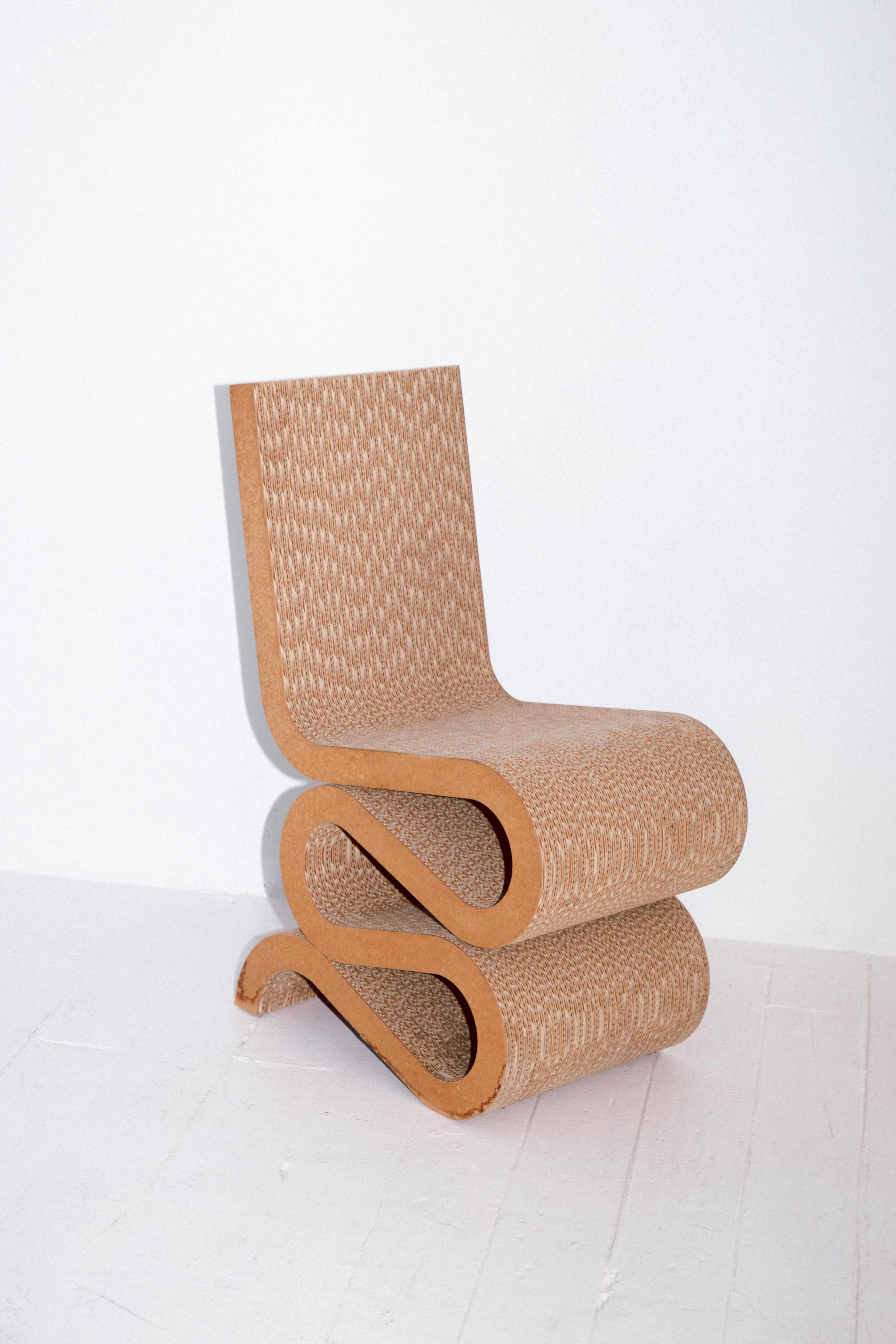 A modern, sculptural chair made of corrugated material, showcasing a unique wavy design.