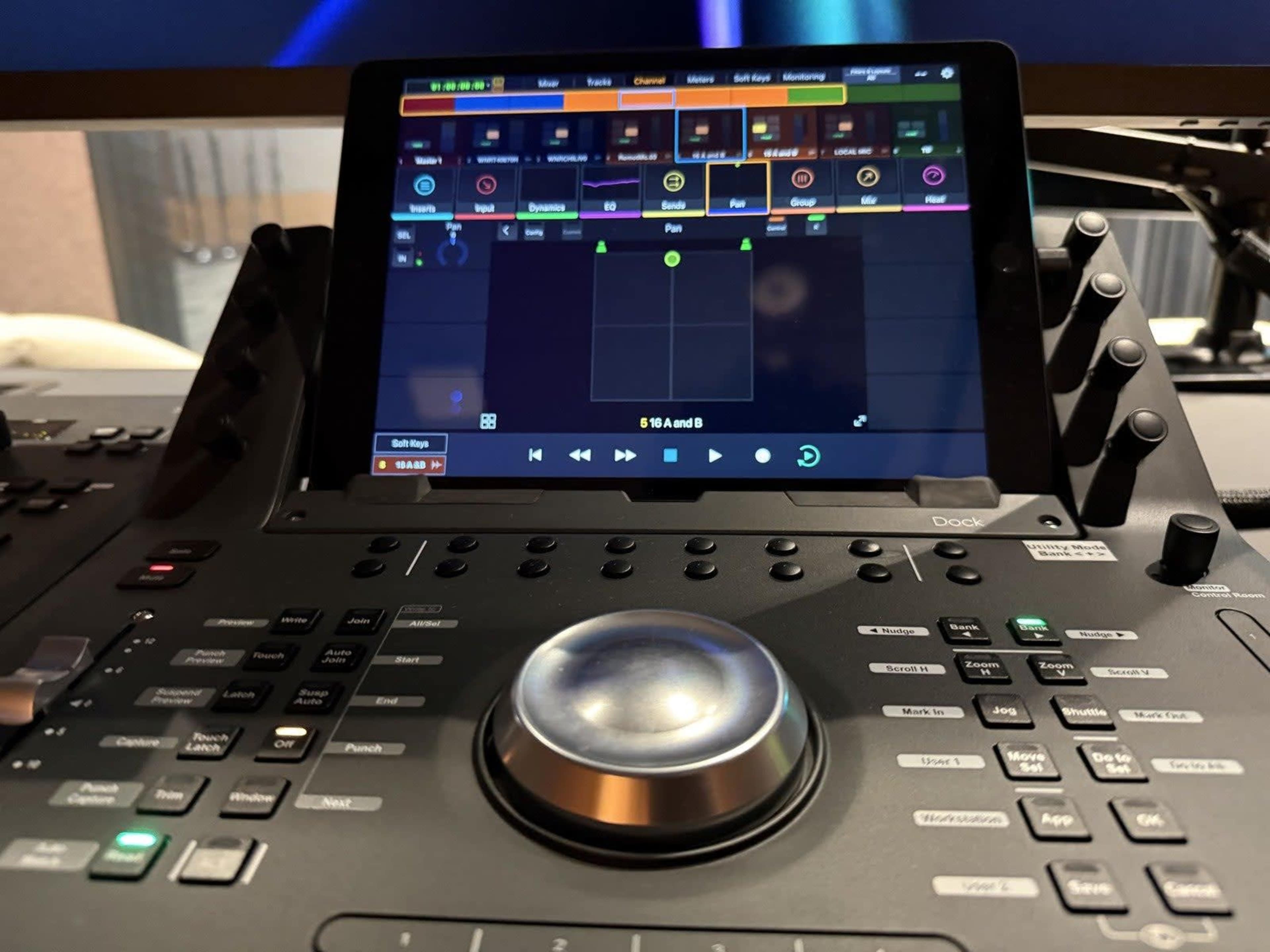 The image shows a digital audio workstation controller with a touchscreen interface, displaying various controls and a musical grid layout.