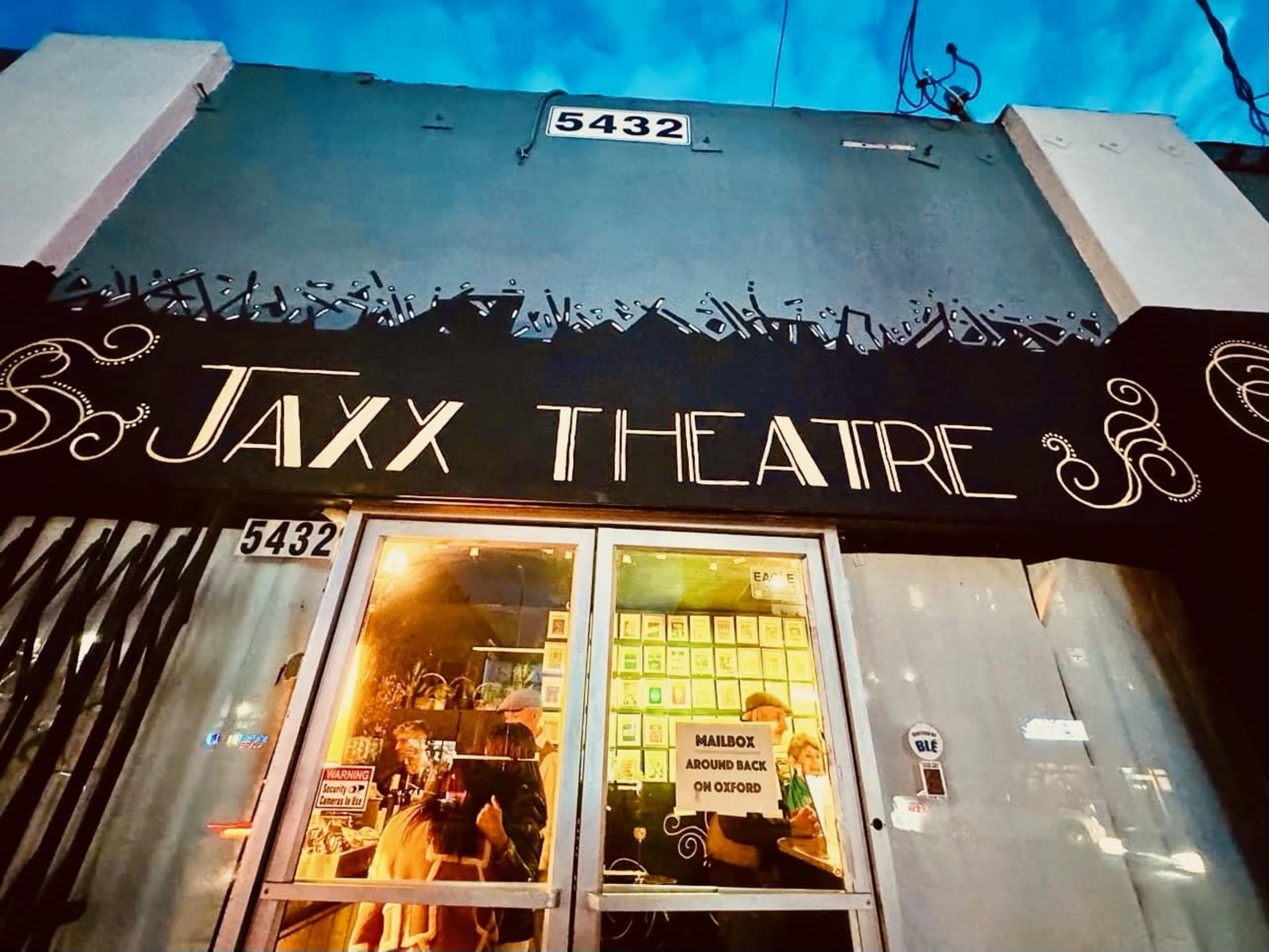The front entrance of Jaxx Theatre, featuring a sign above the door and a visible address on the building.