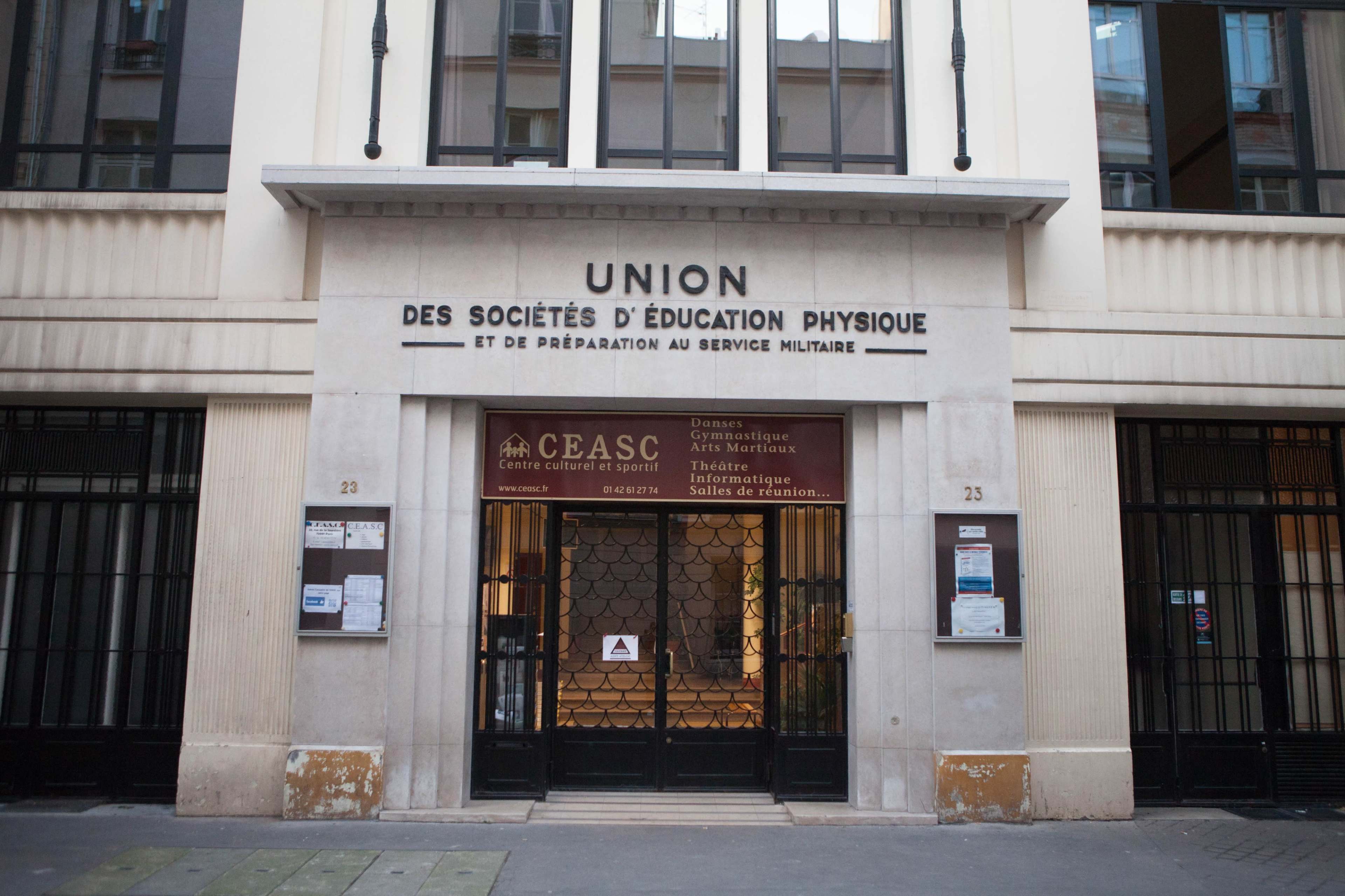 The image shows the entrance of a building labeled "UNION DES SOCIÉTÉS D'ÉDUCATION PHYSIQUE ET DE PRÉPARATION AU SERVICE MILITAIRE," with a sign indicating the CEASC cultural and sports center.