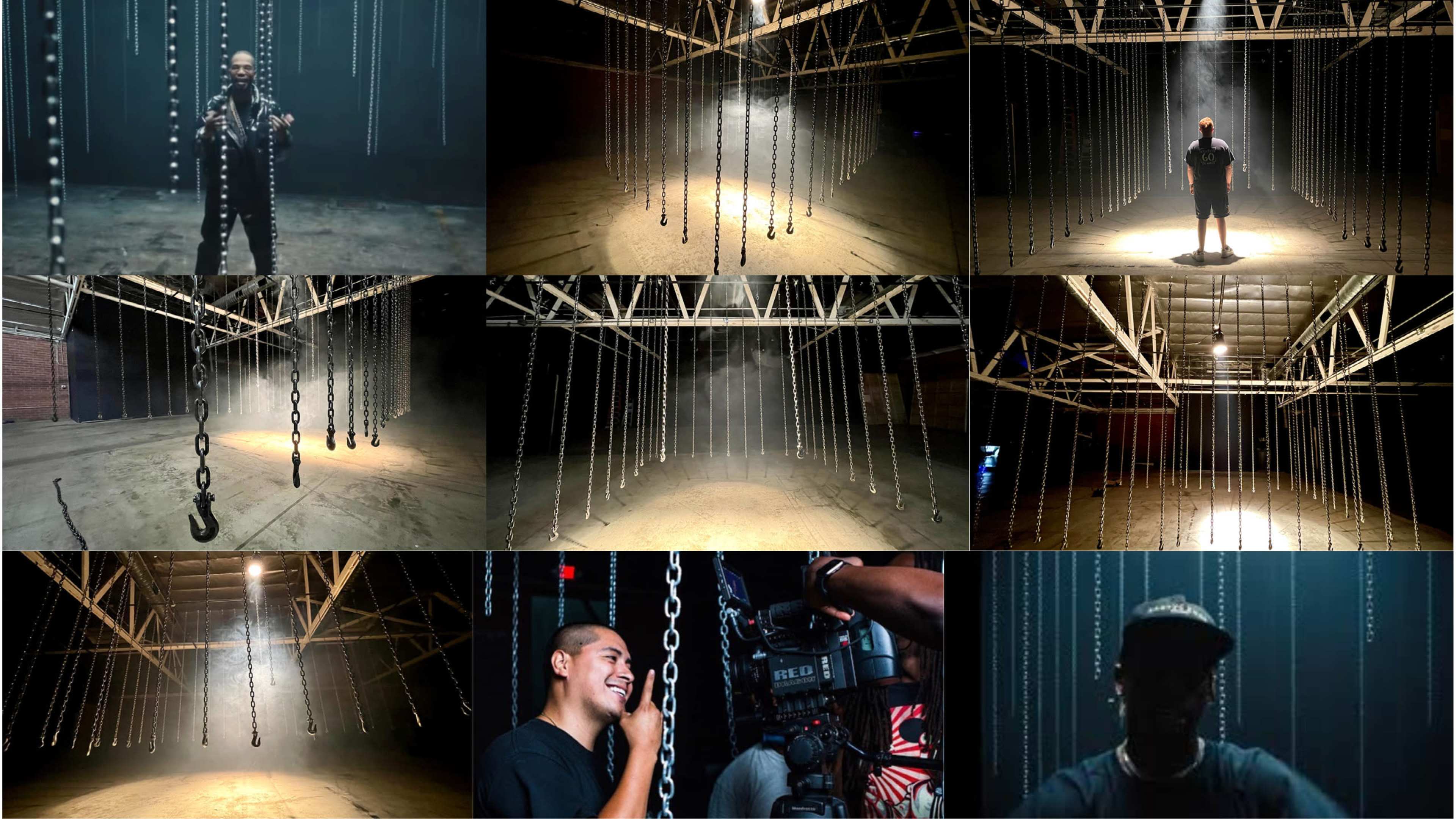A dark warehouse space featuring hanging chains and beams of light illuminating the area, with individuals positioned among the chains.