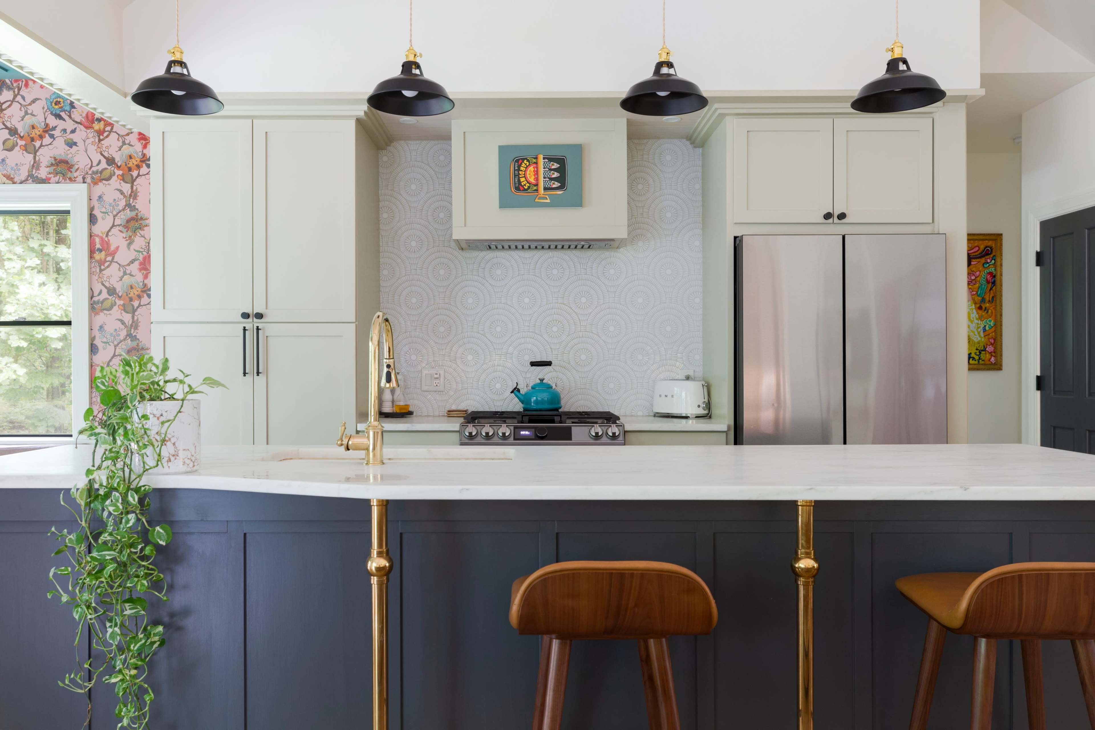 The image shows a modern kitchen featuring a marble island with two wooden stools, dark cabinets, and stainless steel appliances, set against a floral wallpaper backdrop.