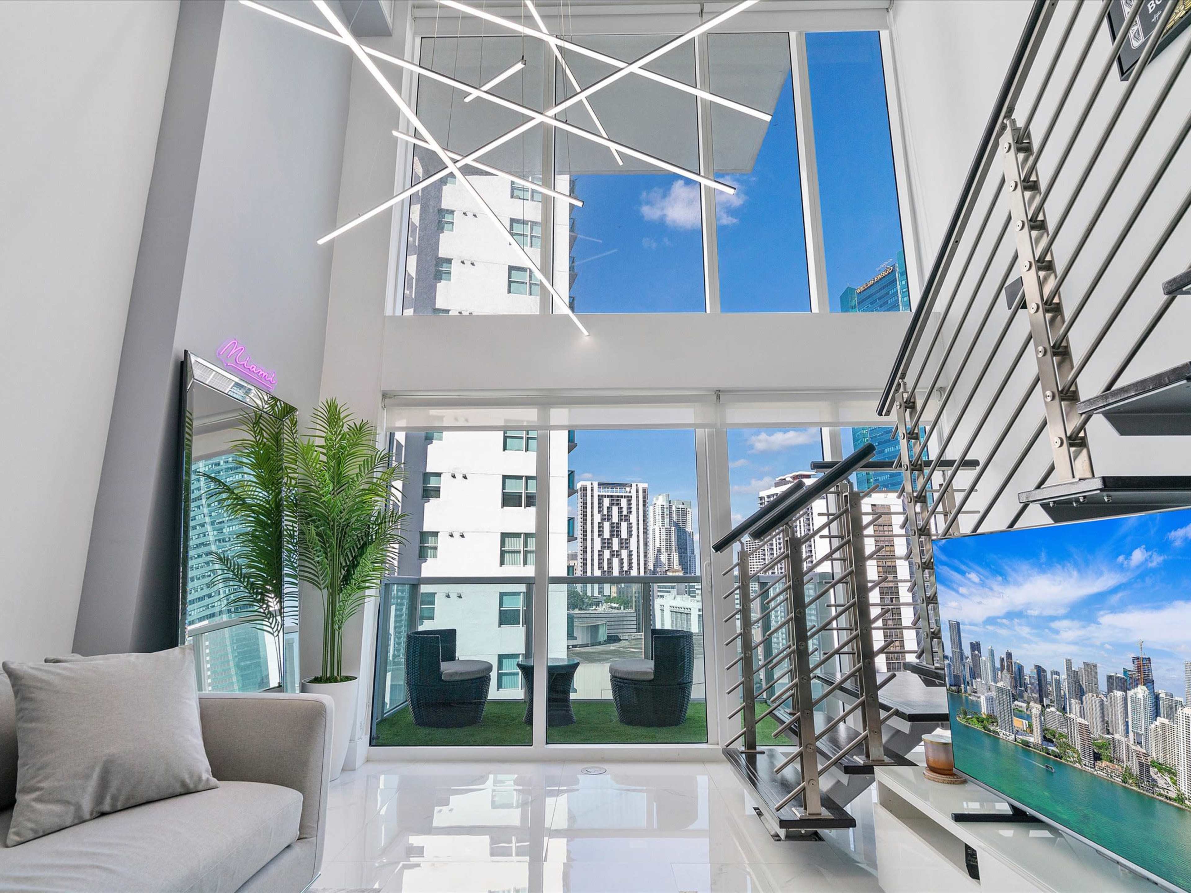 A modern living space with large windows, sleek furniture, and a view of a cityscape outside.