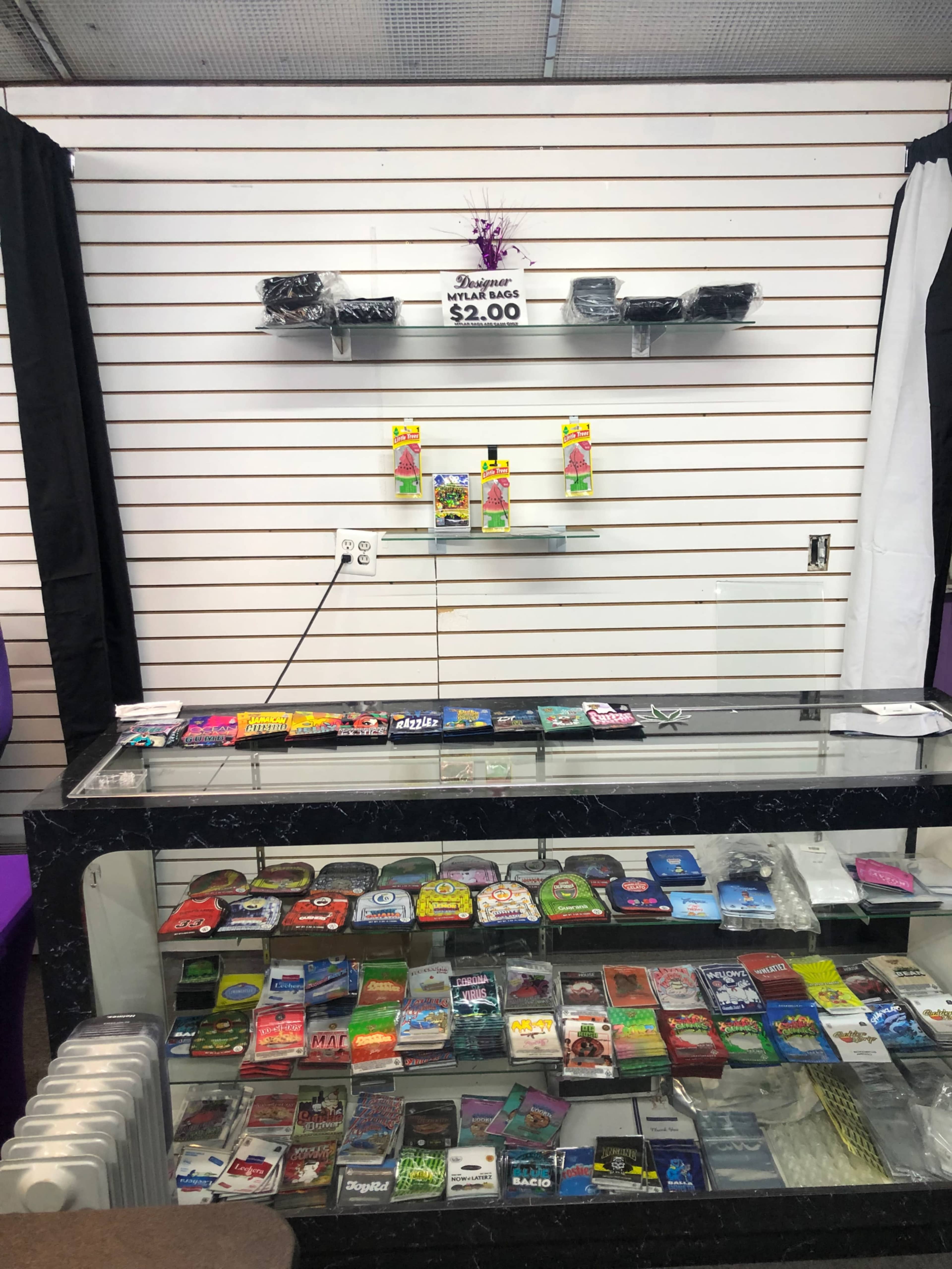 A display case filled with various products, including cards and personal items, with additional items displayed on shelves behind it.