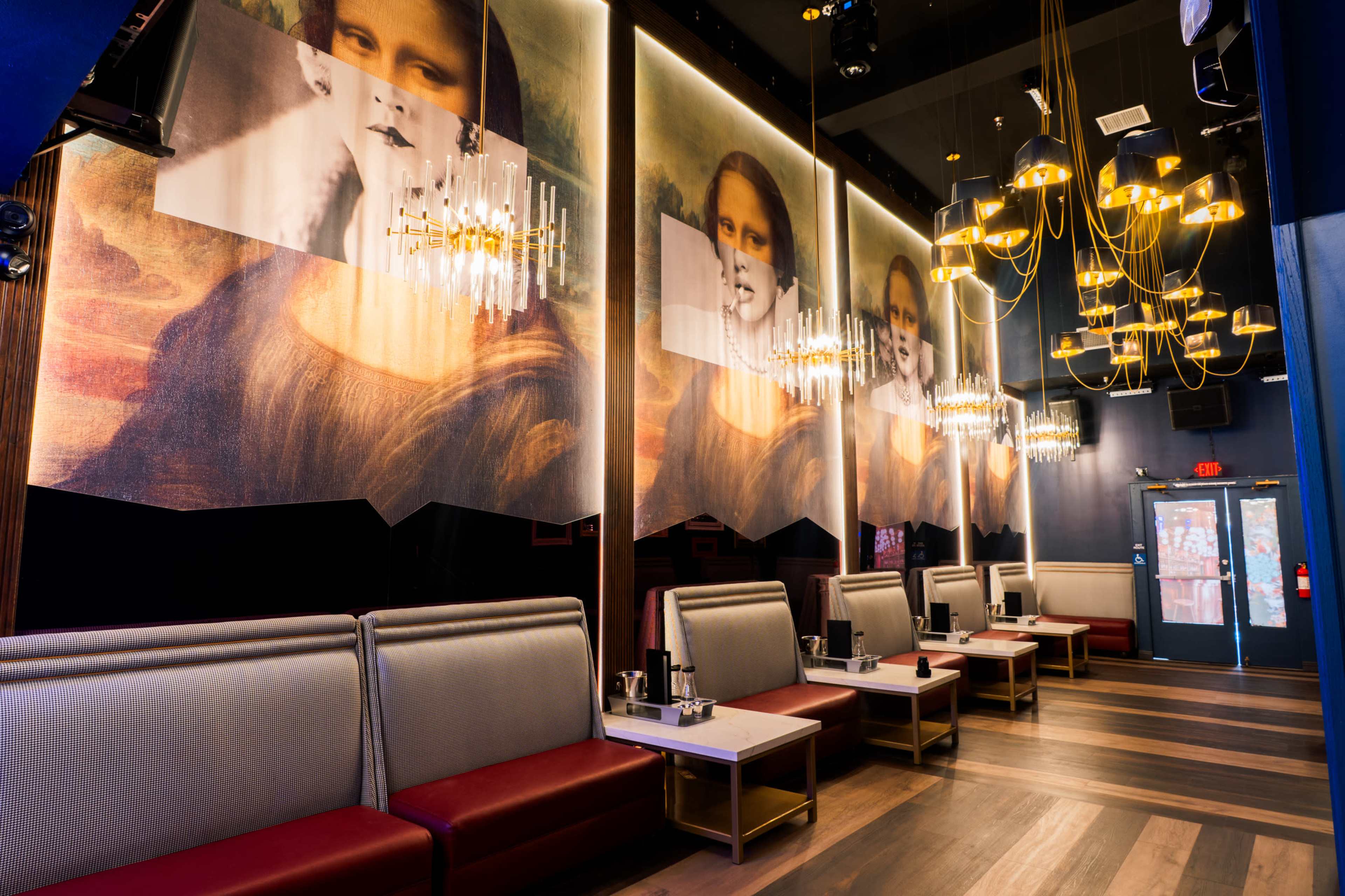 A modern interior of a restaurant featuring large murals of the Mona Lisa on the walls, with elegant seating and hanging light fixtures.