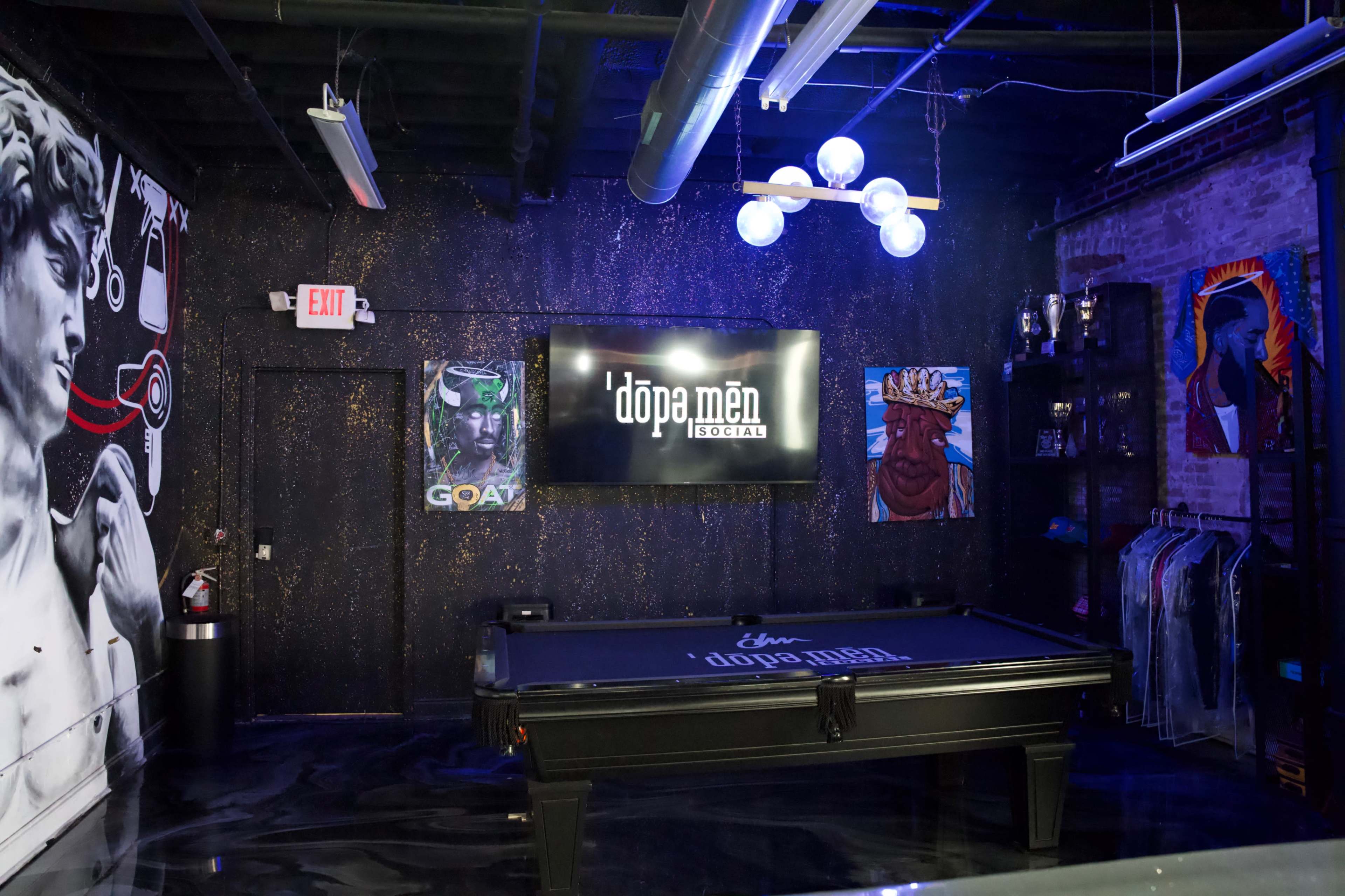 The image shows a stylish lounge area featuring a billiard table, eclectic wall art, and a large screen displaying the logo for "dopa men social."