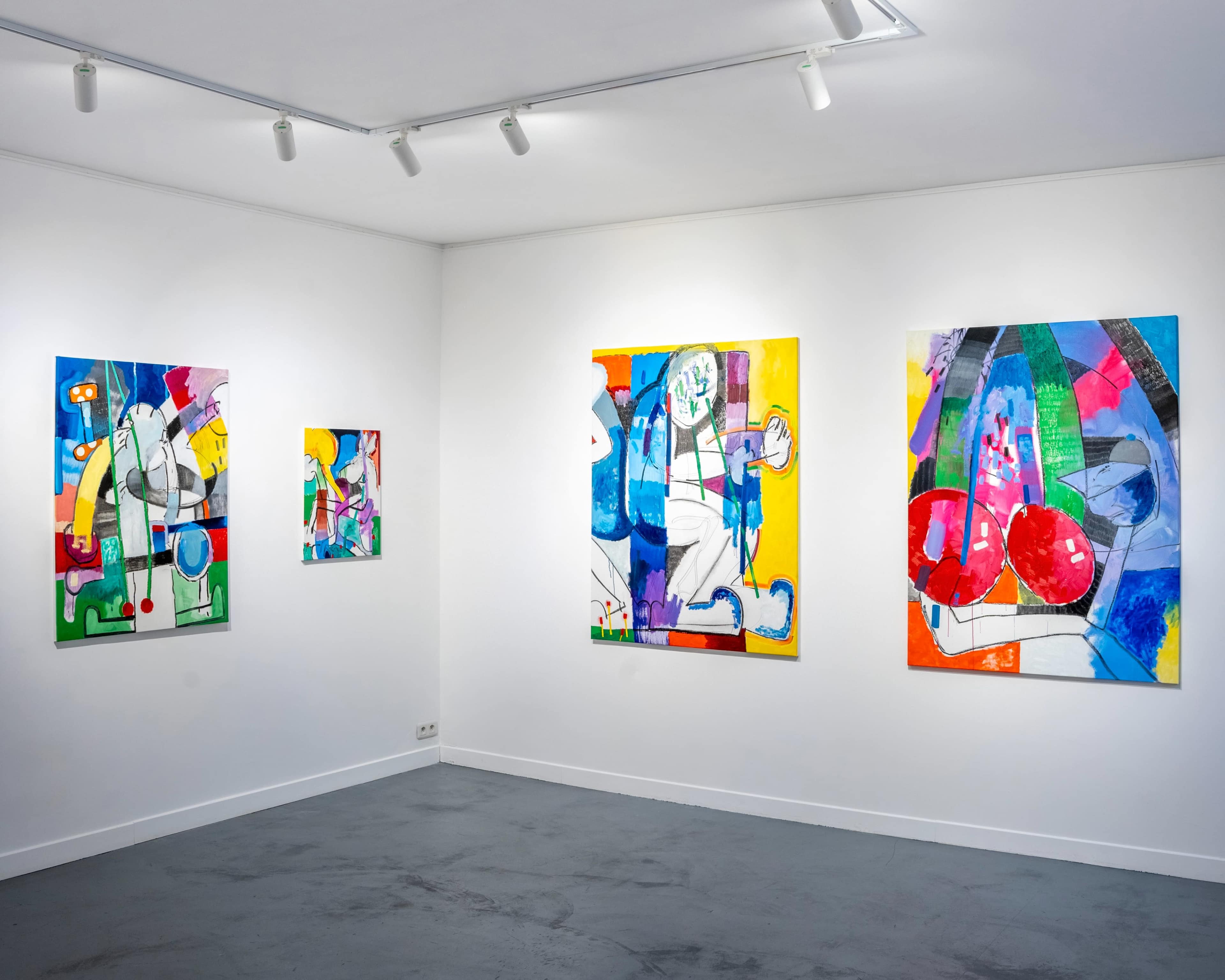 The image shows an art gallery with four colorful abstract paintings displayed on white walls.