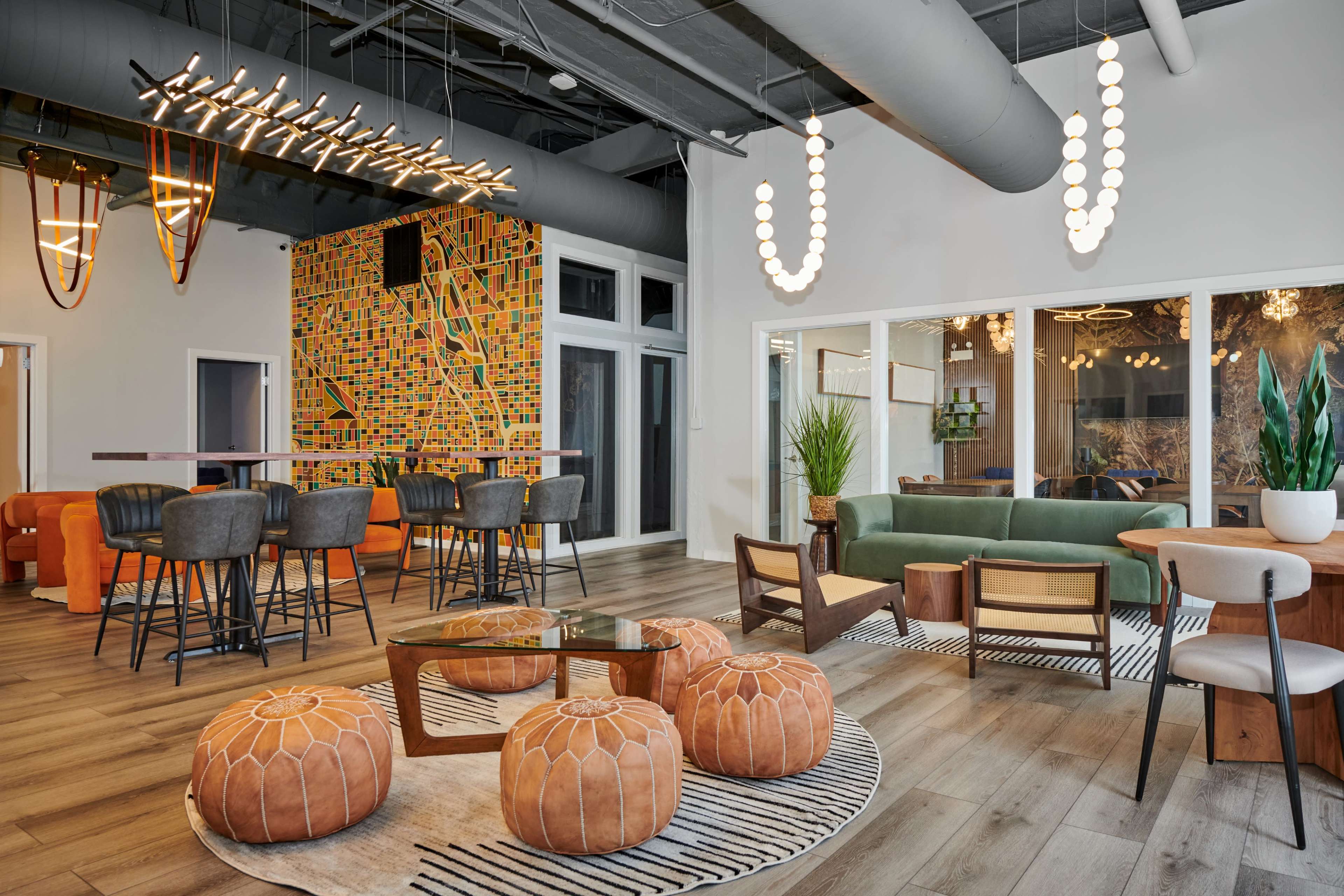 A modern lounge area with a mix of seating, decorative lighting, and vibrant wall art.