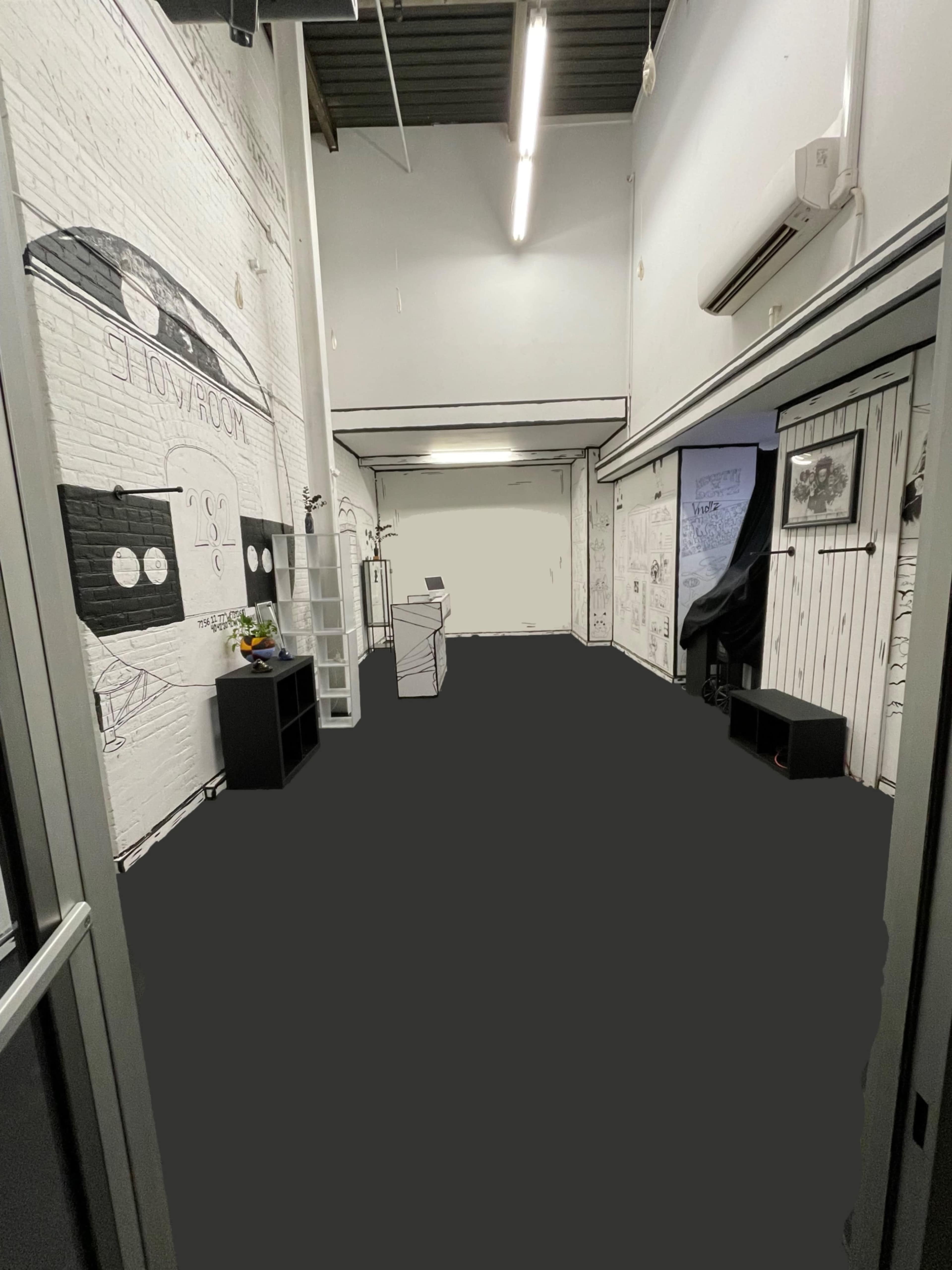 A spacious room with white brick walls, featuring minimalist furniture, and a digital display stand at the far end.