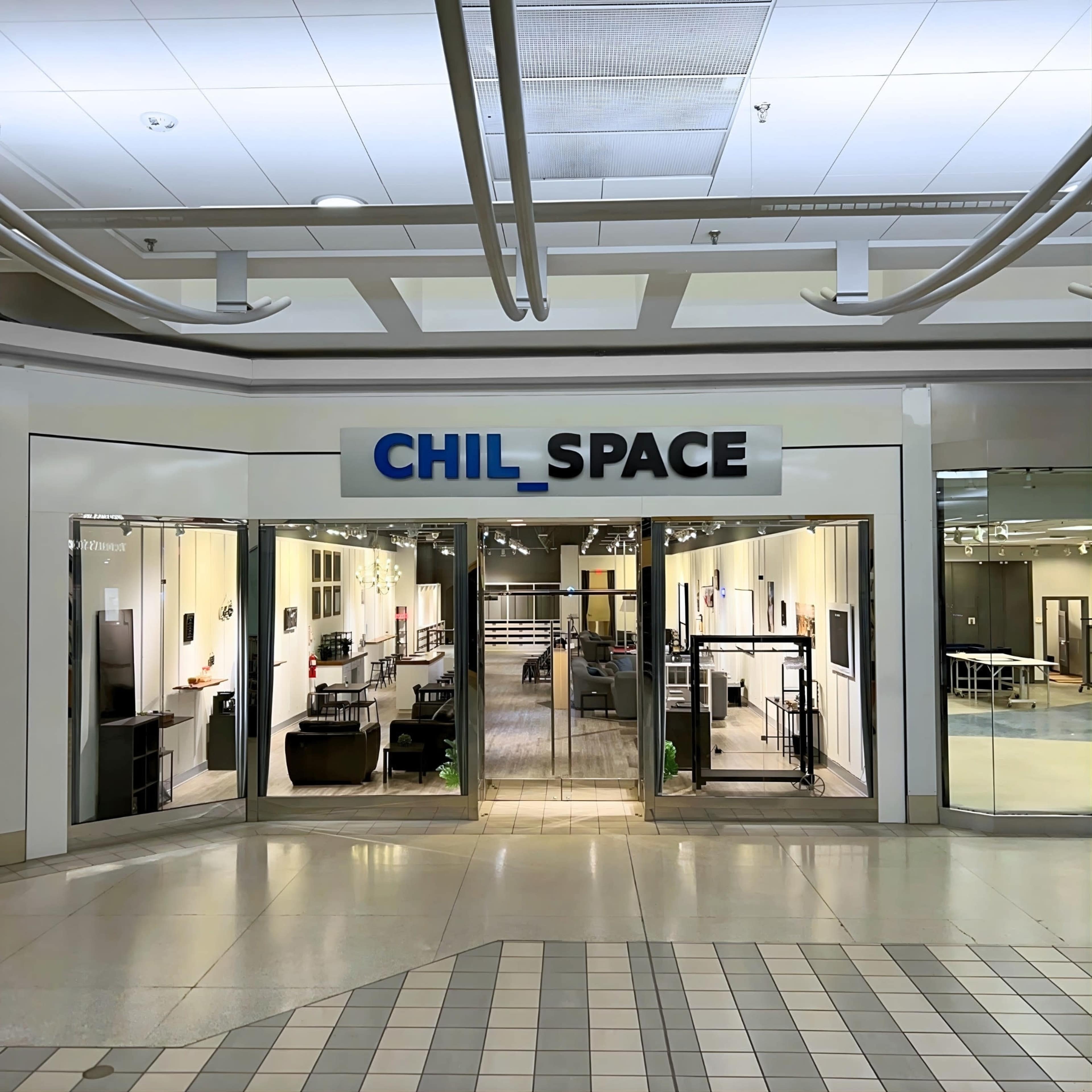 The image shows the entrance of a store named "CHIL_SPACE," featuring large glass windows displaying modern furniture and home decor items inside.