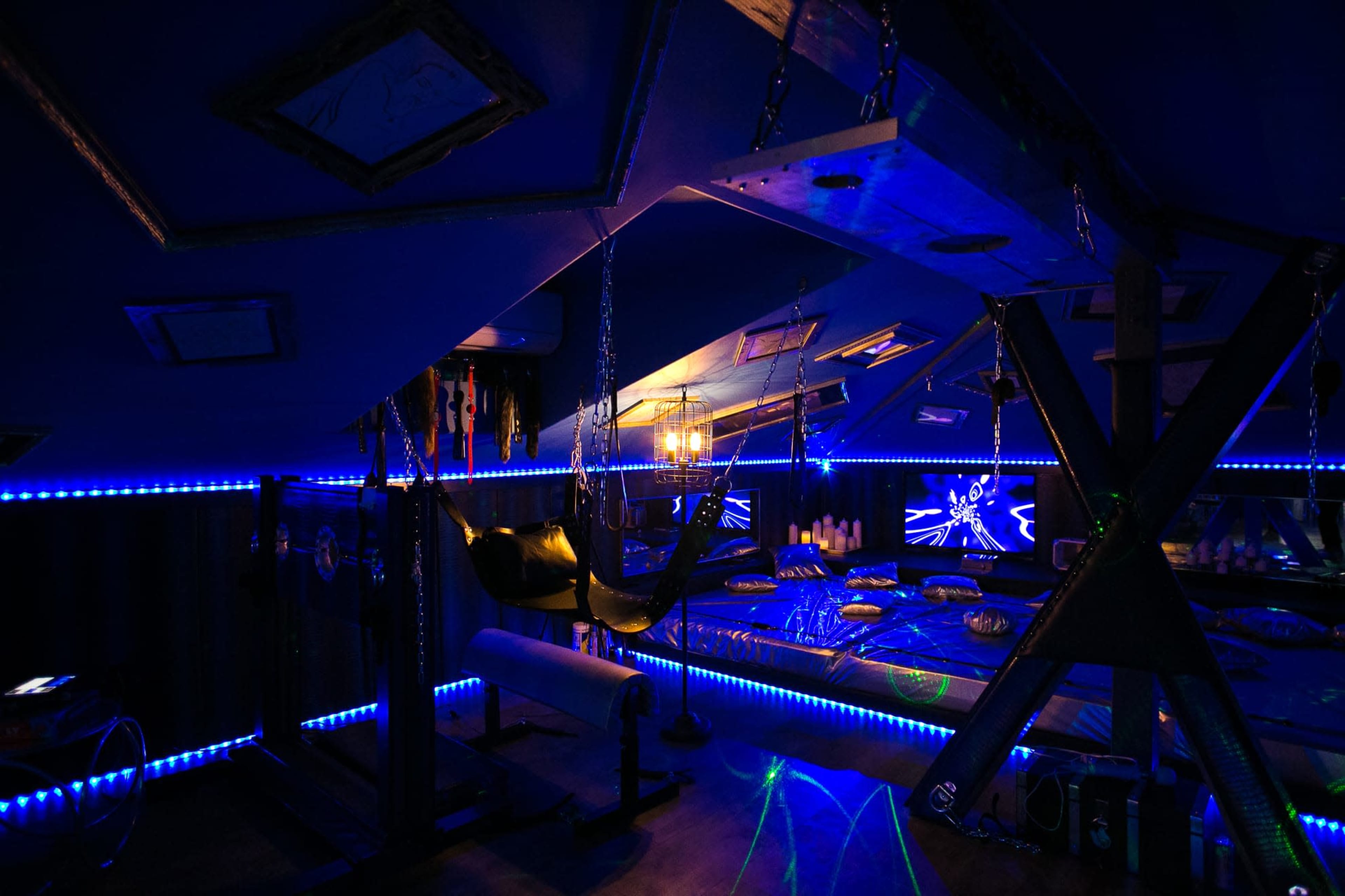 The interior of a room features a hammock, various hanging decorations, and blue LED lighting that illuminates the space.