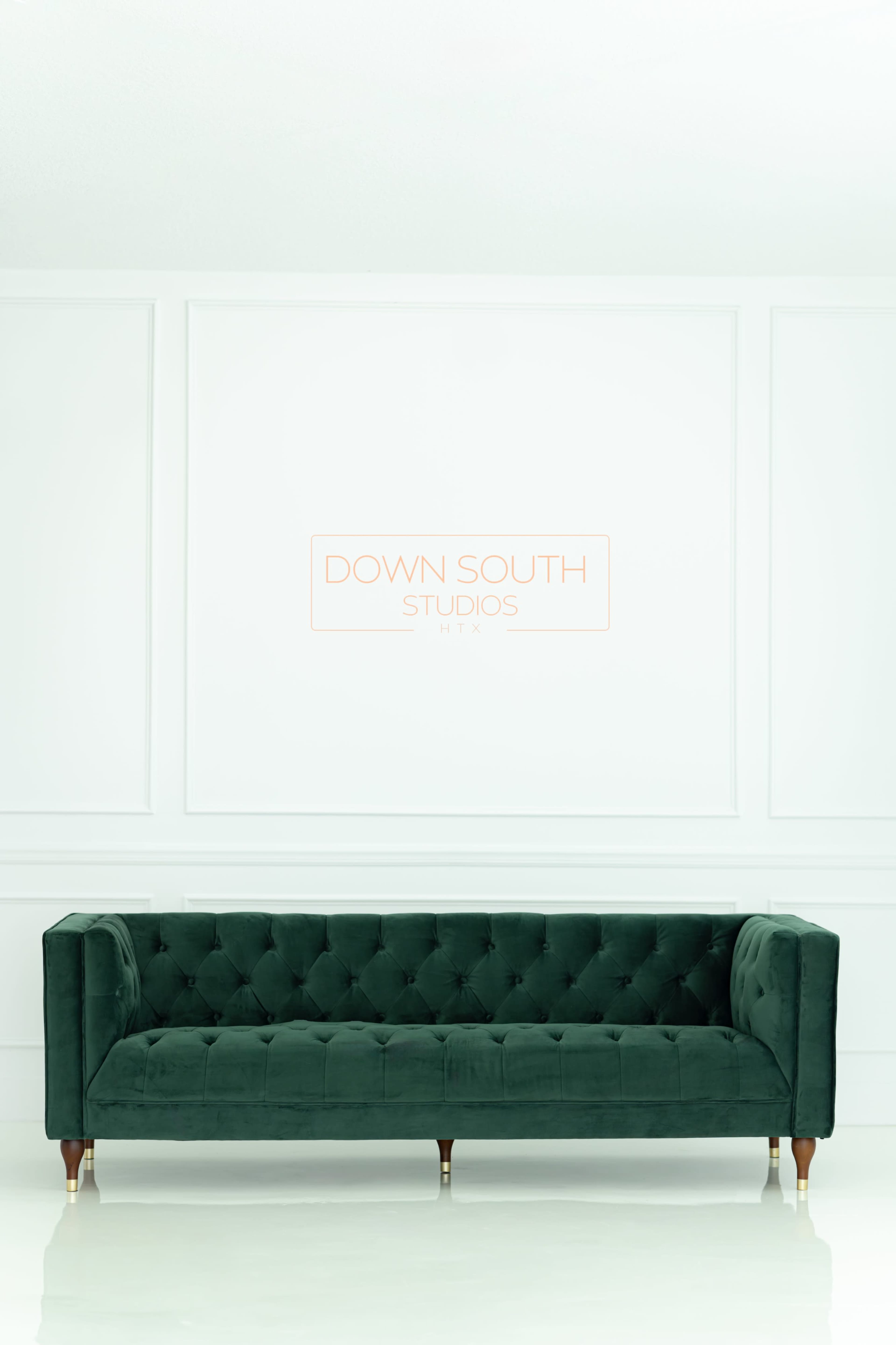 The image features a green tufted sofa in front of a plain white wall with the text "DOWN SOUTH STUDIOS" displayed in the center.