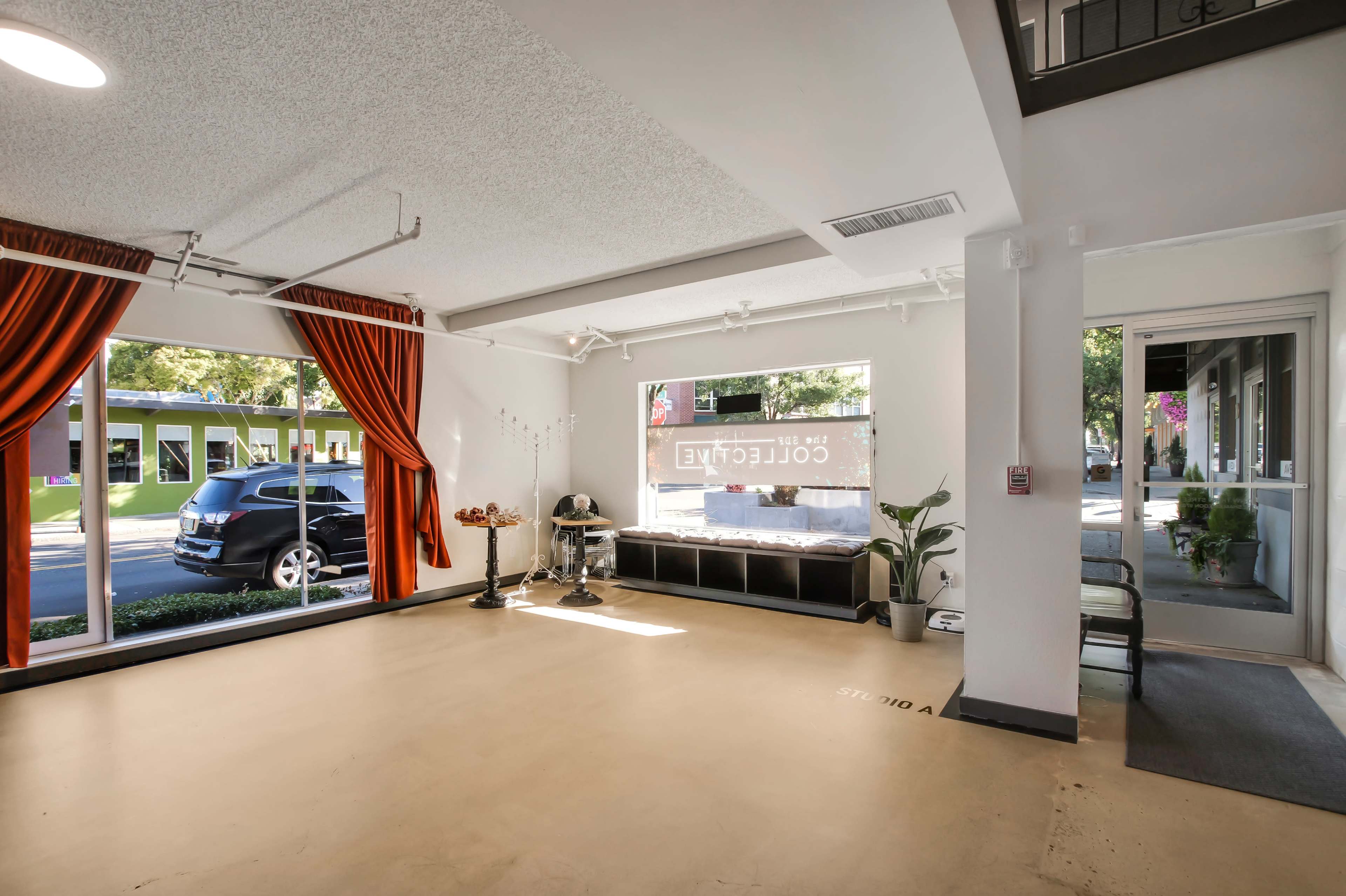 A bright, open space with large windows, a seating area, and a decorative curtain.