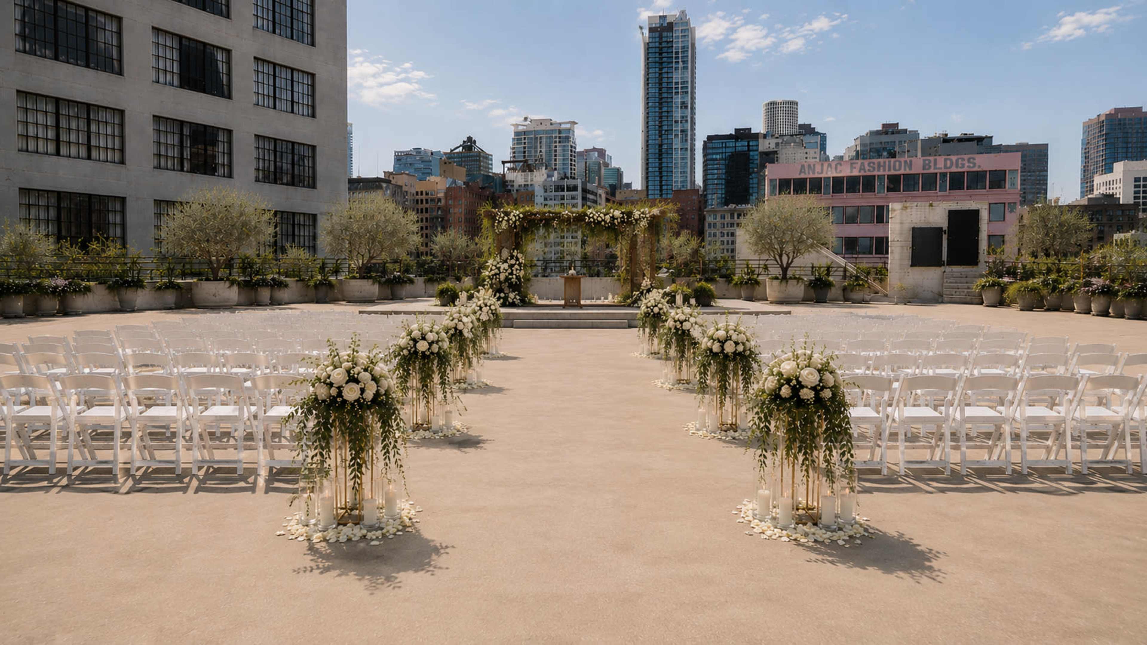 The image shows an outdoor wedding venue with rows of white chairs set up facing a decorated altar, surrounded by city buildings.