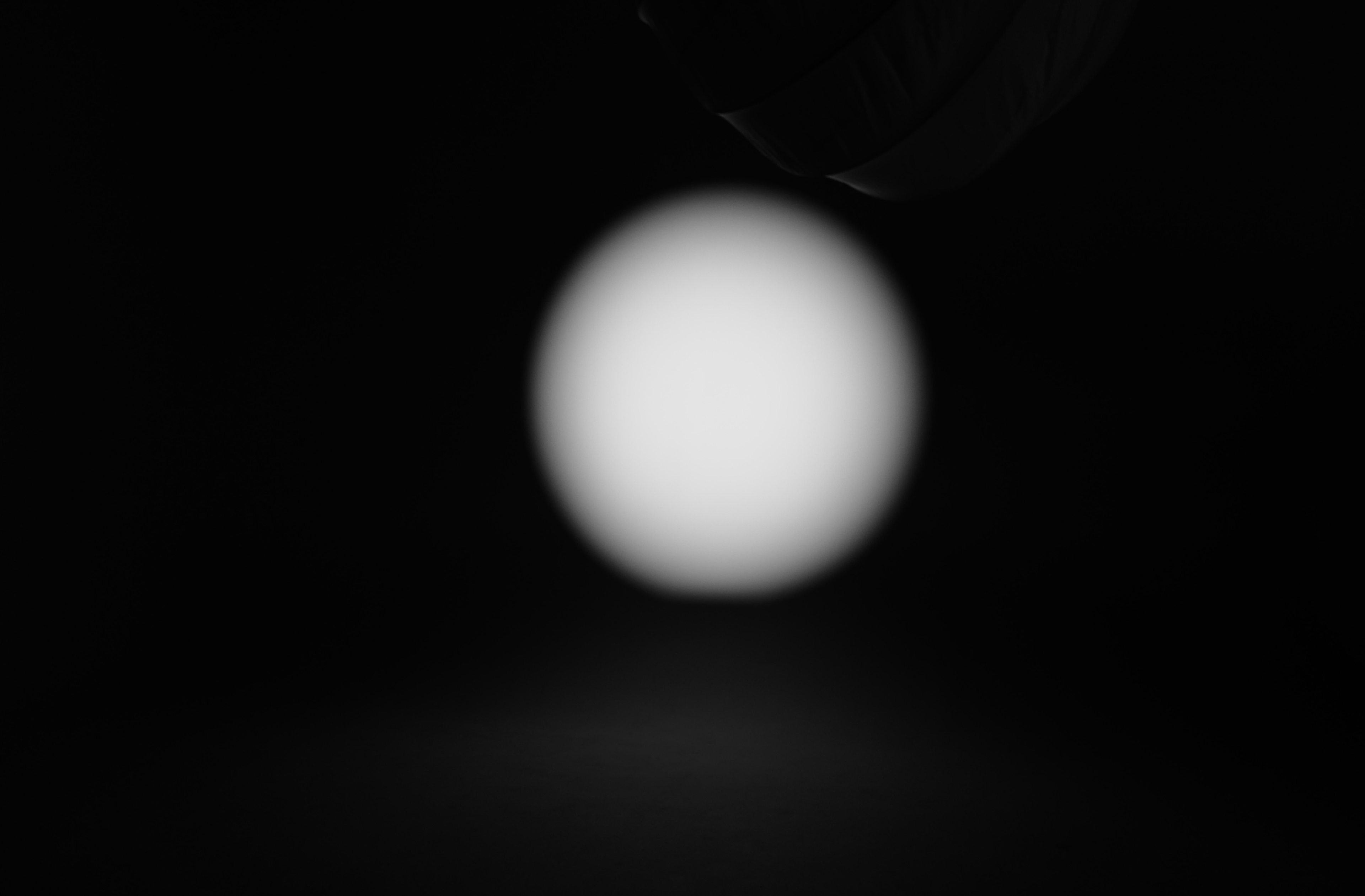 A blurred, circular light source is visible against a dark background.