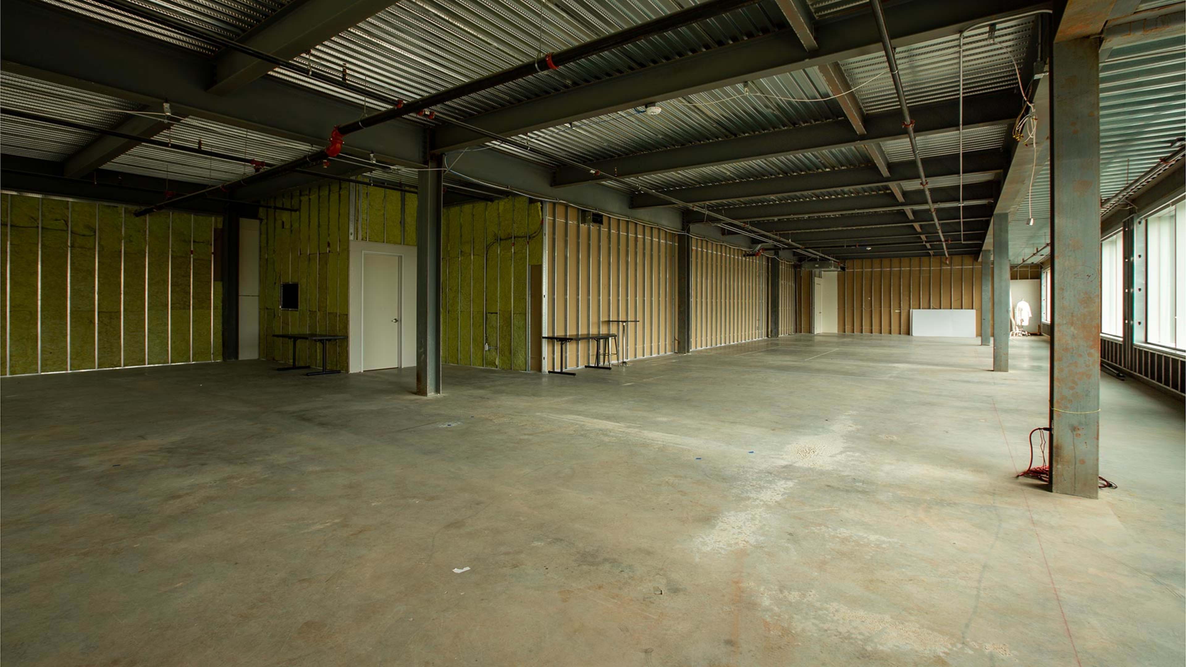 An empty, unfinished indoor space with exposed walls and concrete flooring.